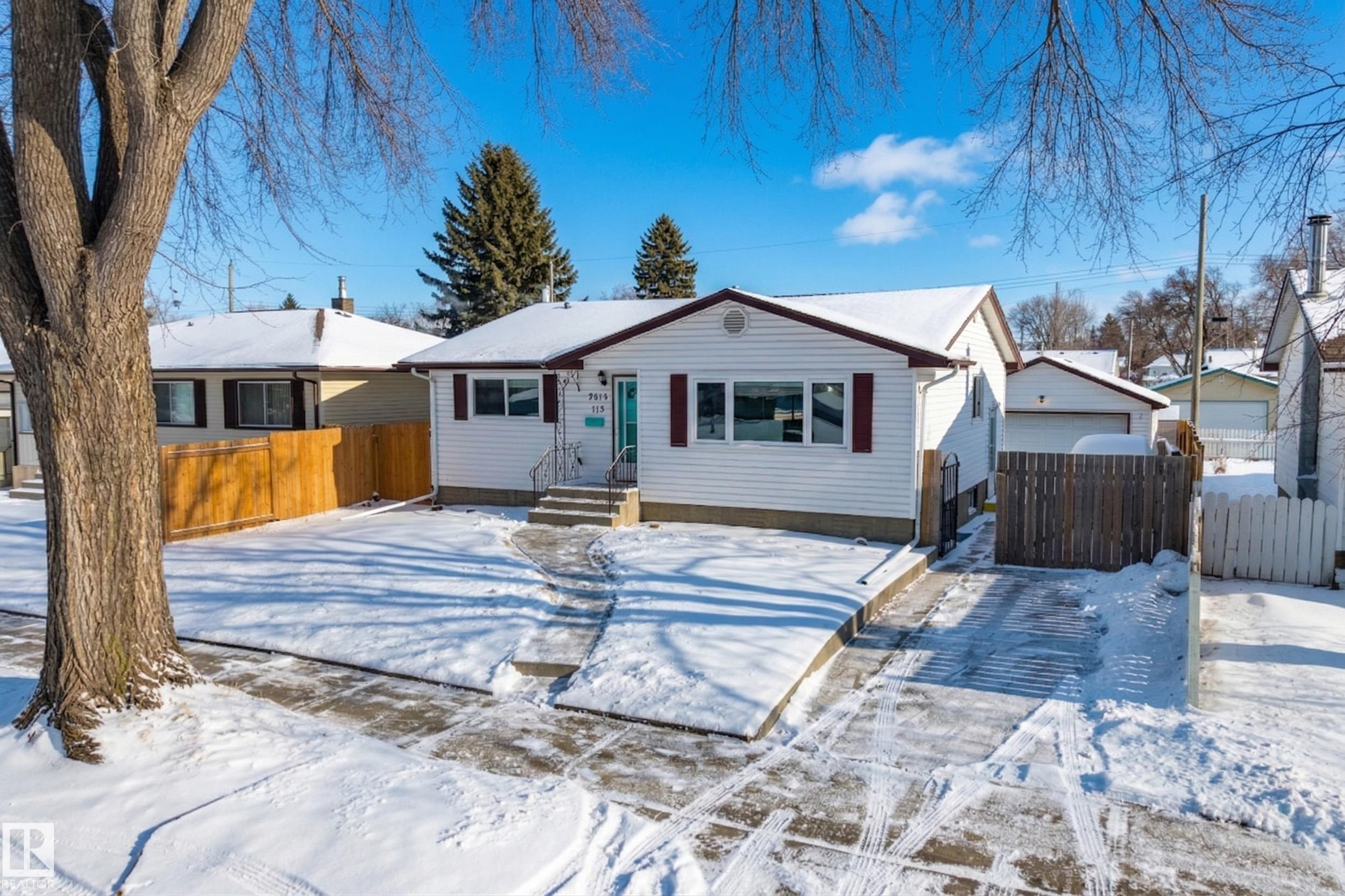 The property features white siding with dark red window shutters, a front walkway, and a driveway leading to a detached garage - 3613 113 Avenue, Edmonton, AB - Outdoor