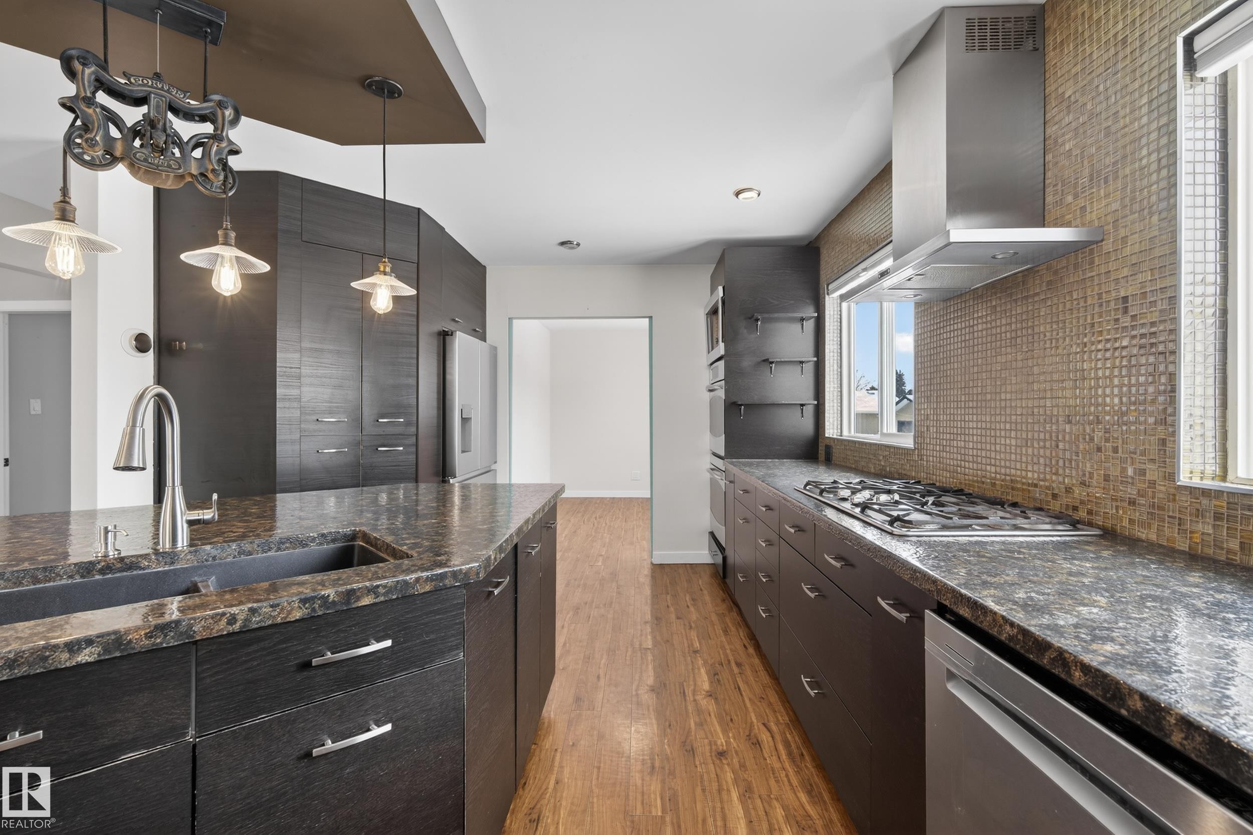 The kitchen features dark wood cabinetry, granite countertops, and stainless steel appliances - 3613 113 Avenue, Edmonton, AB - Indoor Photo Showing Kitchen With Upgraded Kitchen