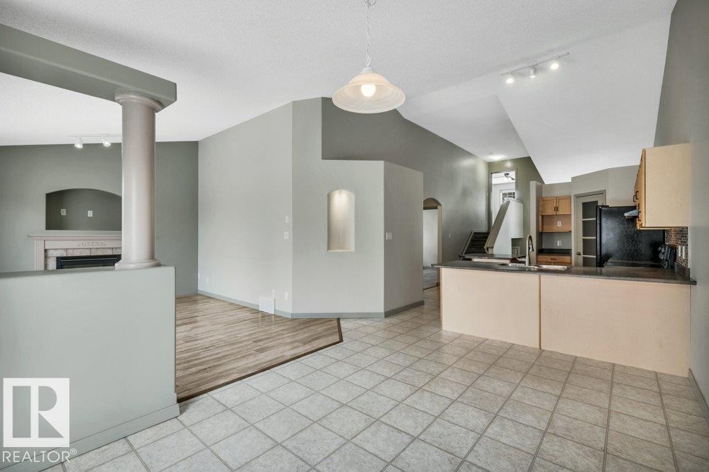 The property features an open-concept living area with tile flooring in one section and wood-look flooring in another - 902 Graham Wynd, Edmonton, AB - Indoor Photo Showing Kitchen