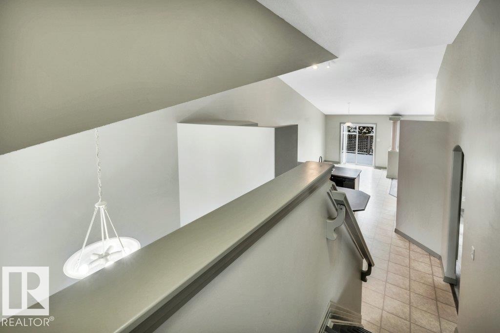 The property features vaulted ceilings, light-colored walls, and tiled flooring - 902 Graham Wynd, Edmonton, AB - Indoor Photo Showing Other Room
