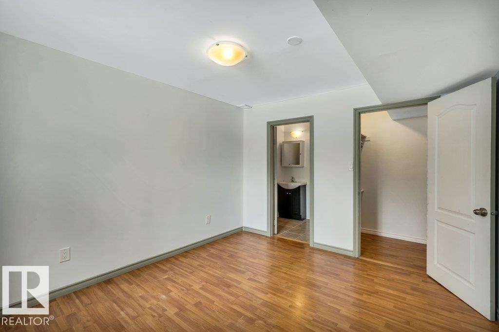 This room features light-colored walls, wood-style flooring, and a ceiling light fixture - 902 Graham Wynd, Edmonton, AB - Indoor Photo Showing Other Room