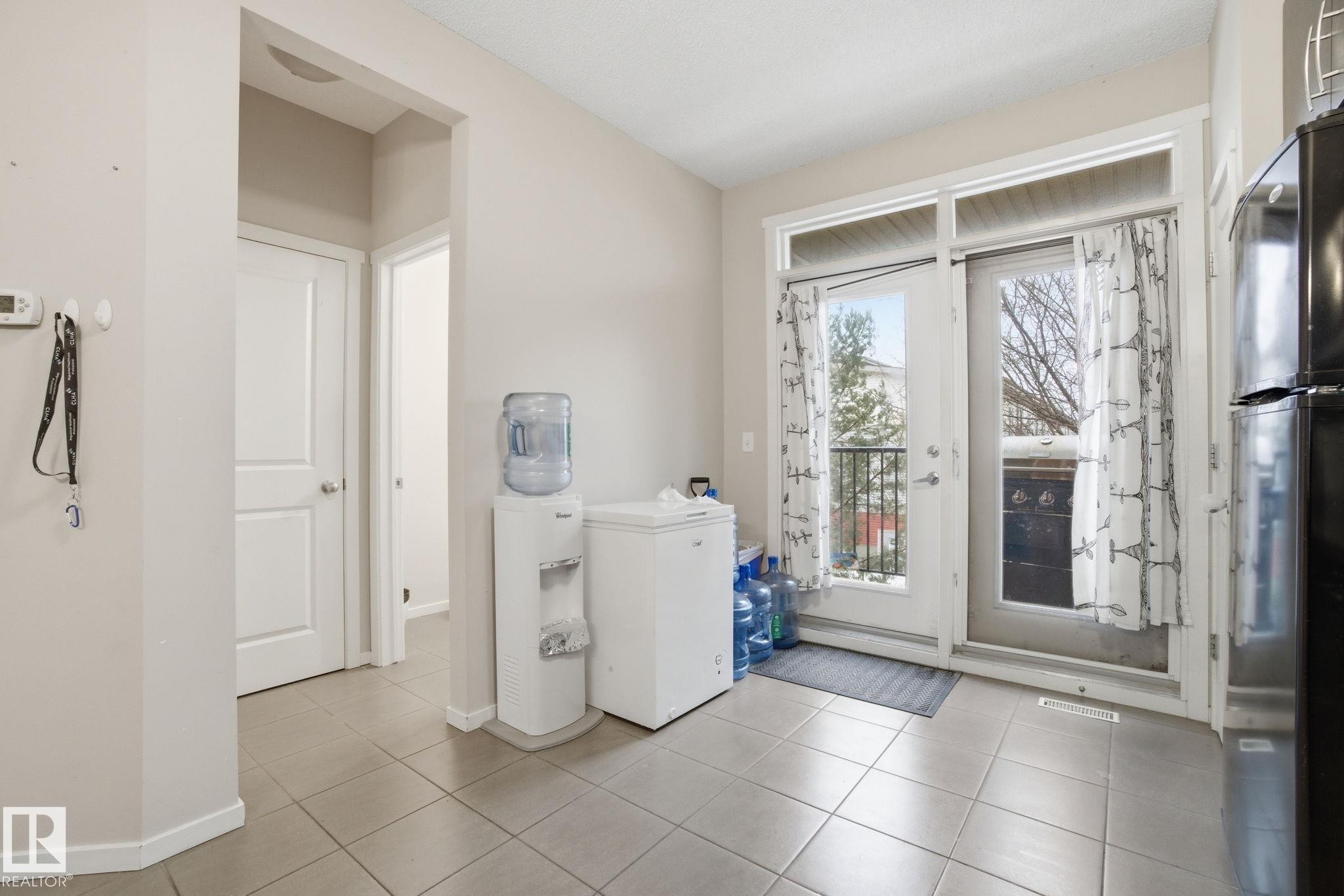 The property features light-colored walls and tiled flooring throughout this area - 75 603 Watt Boulevard, Edmonton, AB - Indoor Photo Showing Laundry Room