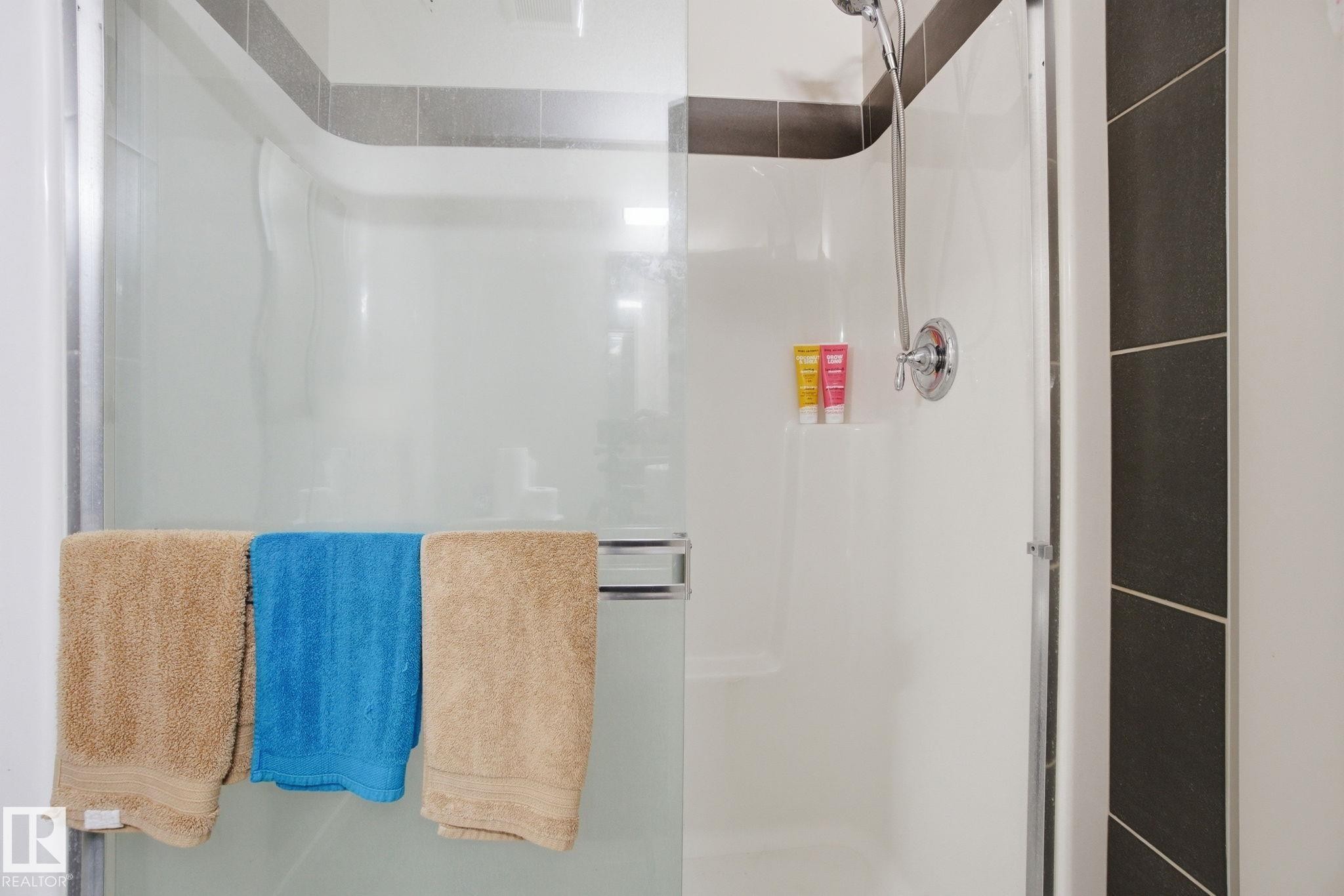 The bathroom features a shower with a clear glass enclosure and a chrome shower head fixture - 75 603 Watt Boulevard, Edmonton, AB - Indoor Photo Showing Bathroom