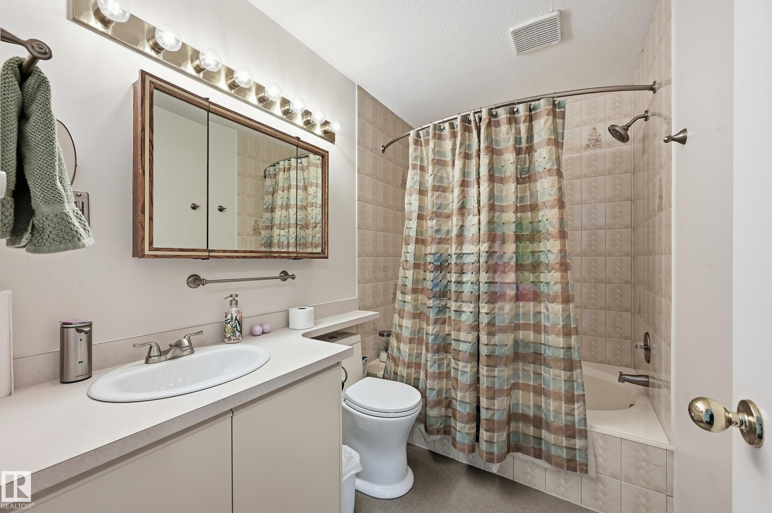 The bathroom features a vanity with an integrated sink, a mirrored medicine cabinet, and a tiled shower and tub combination - 85 Arlington Drive, St. Albert, AB - Indoor Photo Showing Bathroom