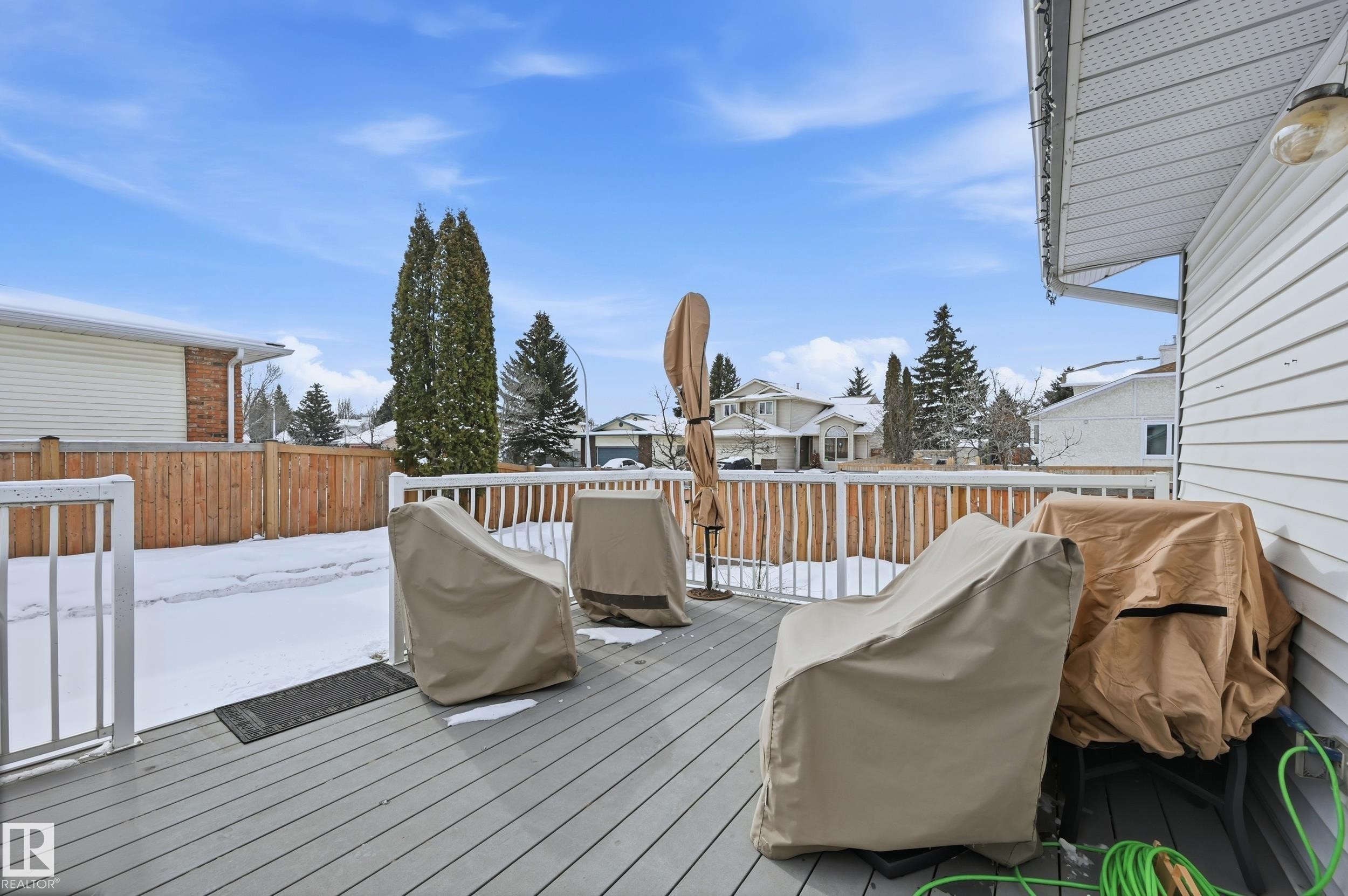 The property features a spacious deck with white railings and a view of the surrounding neighborhood - 85 Arlington Drive, St. Albert, AB - Outdoor With Deck Patio Veranda With Exterior