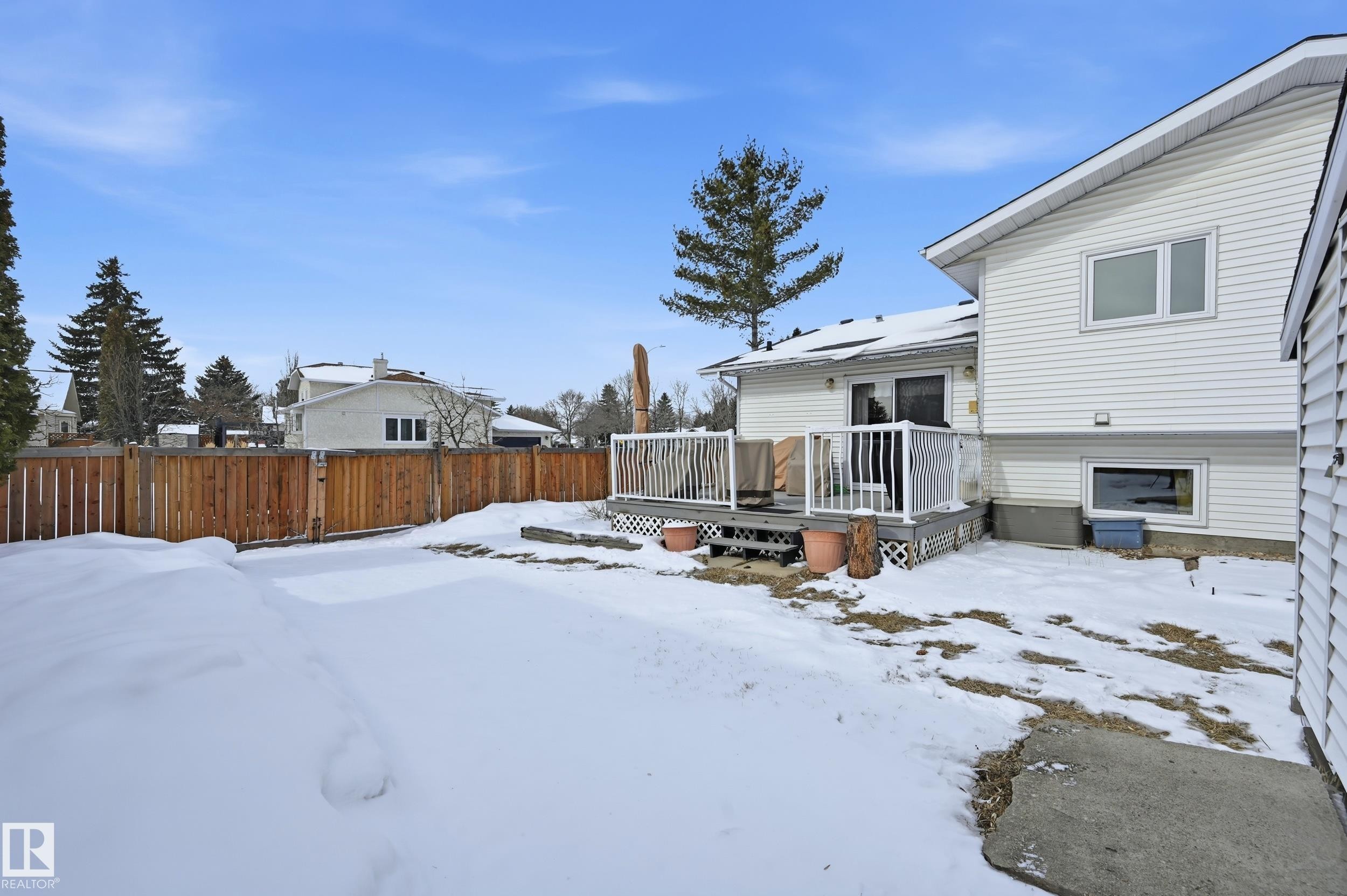 The property features a private fenced yard, a spacious deck, and white vinyl siding - 85 Arlington Drive, St. Albert, AB - Outdoor