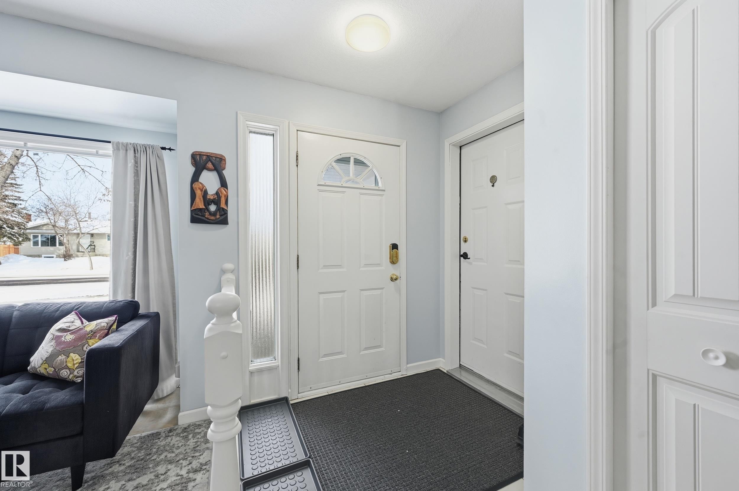 Entryway featuring light blue walls, two white panel doors, and a window with a view of the outdoors - 85 Arlington Drive, St. Albert, AB - Indoor Photo Showing Other Room