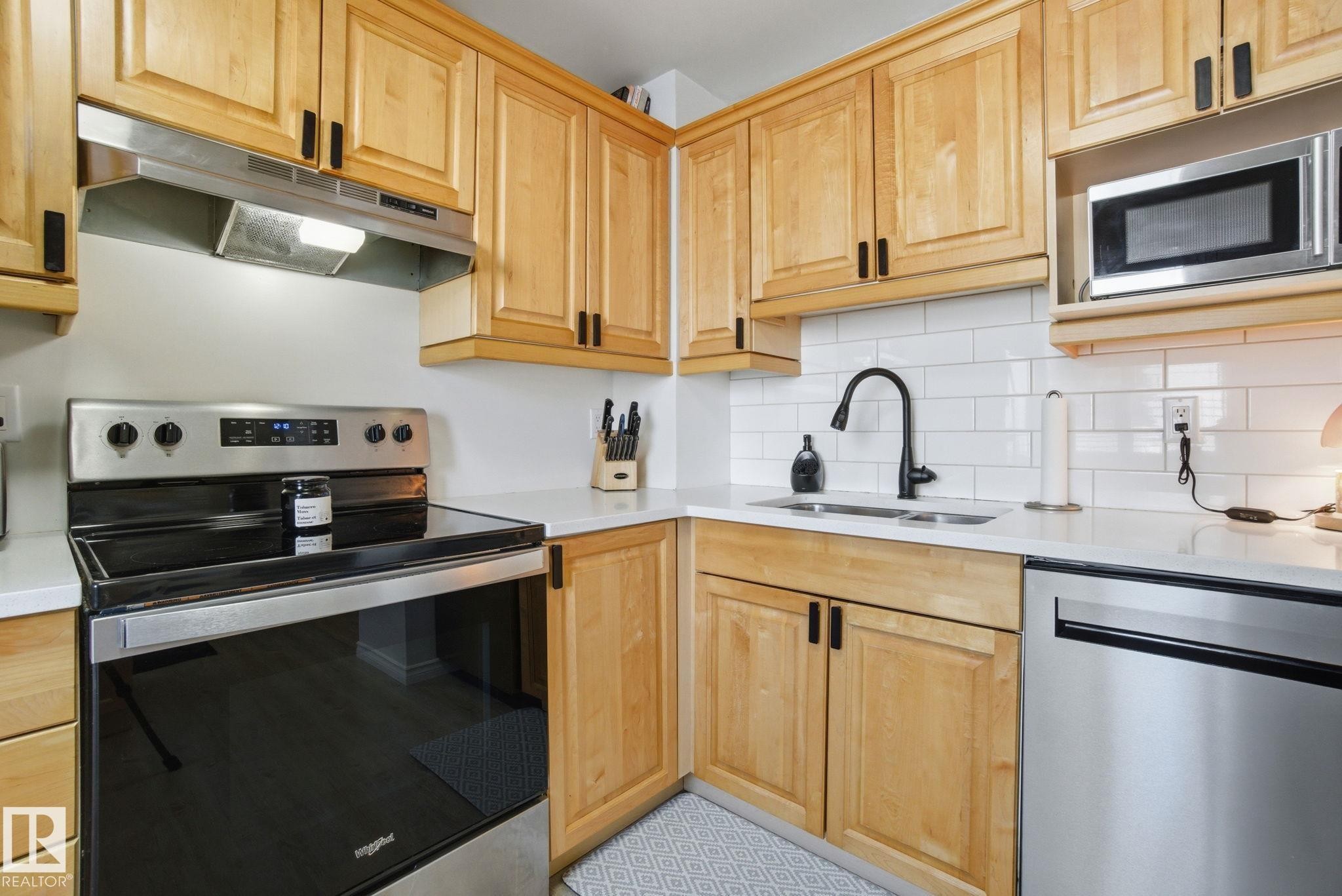 The kitchen features light wood cabinetry, stainless steel appliances, and white subway tile backsplash - 29 9619 180 Street, Edmonton, AB - Indoor Photo Showing Kitchen With Double Sink