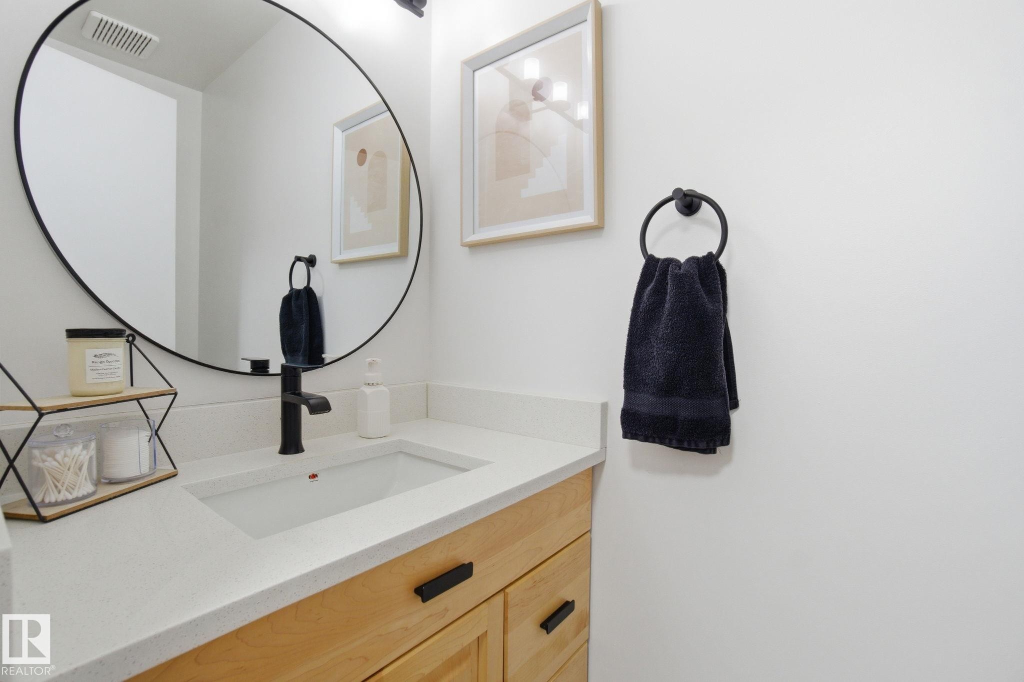 Bathroom vanity featuring a light-toned countertop, an undermount sink, and a black faucet - 29 9619 180 Street, Edmonton, AB - Indoor Photo Showing Bathroom