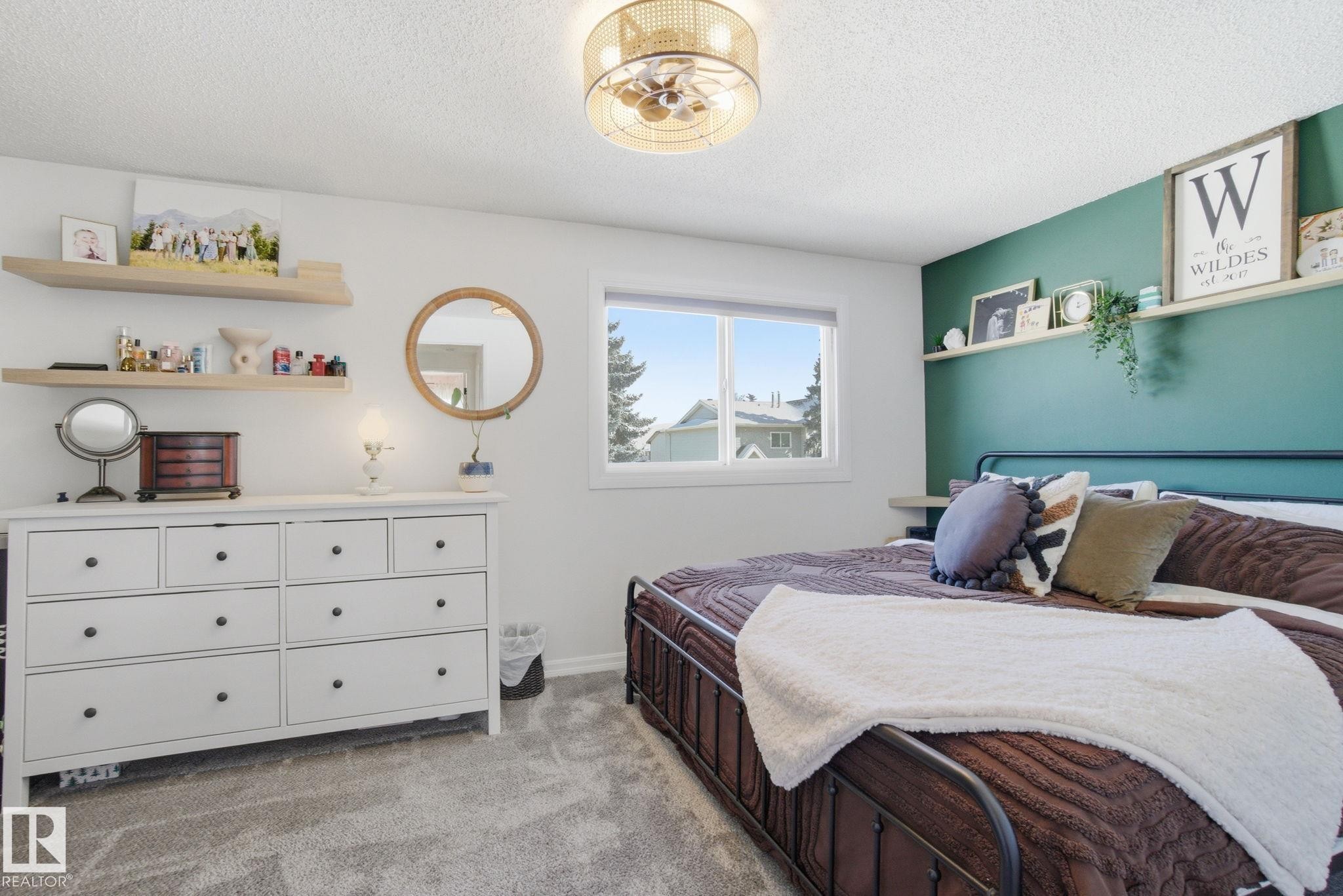 This room features a window with an exterior view, a ceiling fan with integrated lighting, and shelves for display - 29 9619 180 Street, Edmonton, AB - Indoor Photo Showing Bedroom
