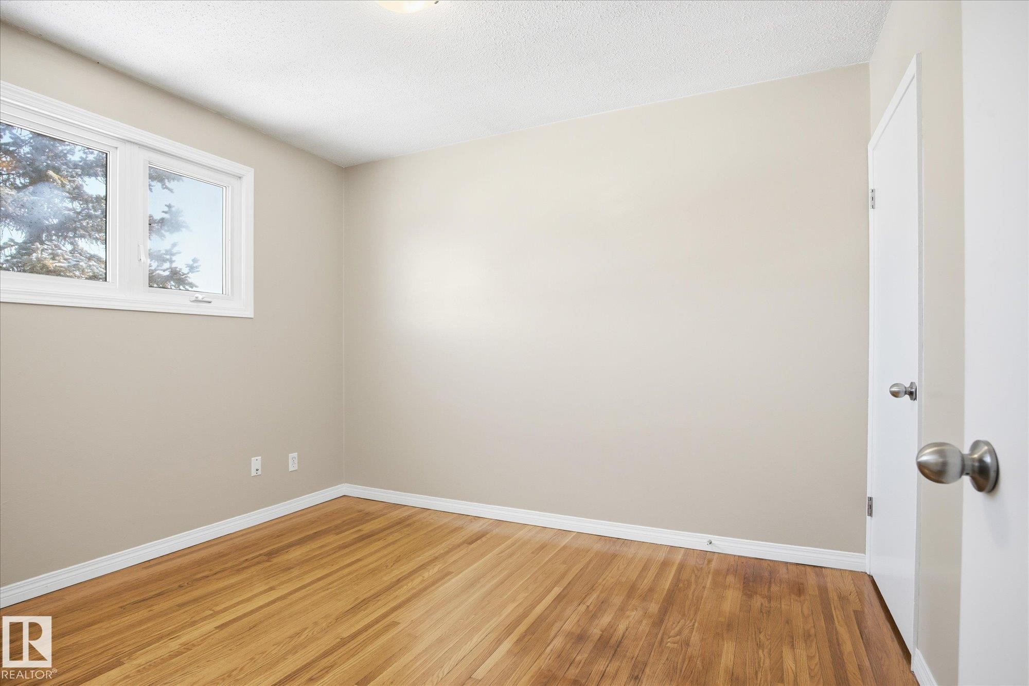 This room features hardwood flooring, light-colored walls, and a window providing natural light - 6 Garden Crescent, St. Albert, AB - Indoor Photo Showing Other Room