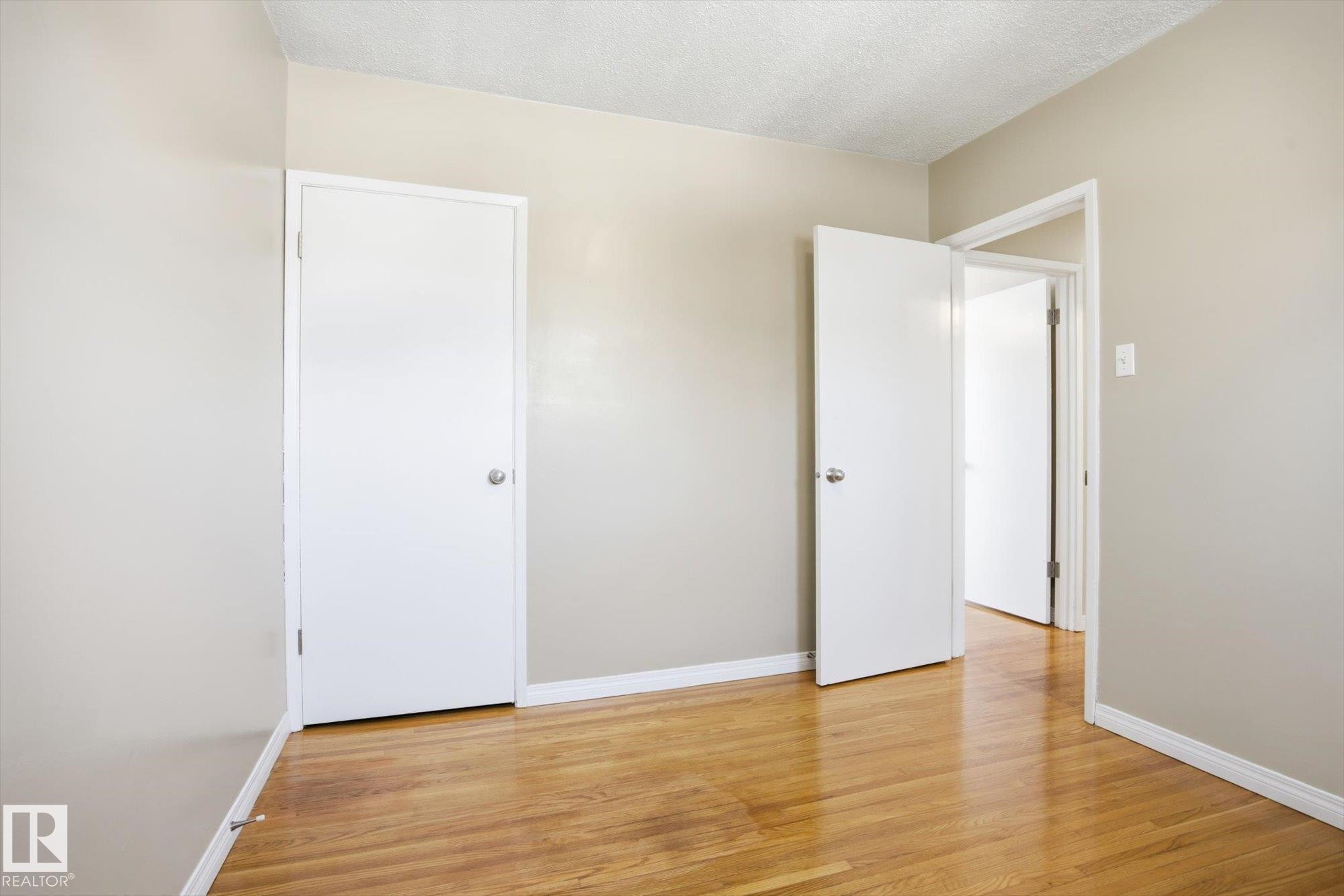 This room features hardwood floors and neutral-toned walls, providing a versatile space - 6 Garden Crescent, St. Albert, AB - Indoor Photo Showing Other Room