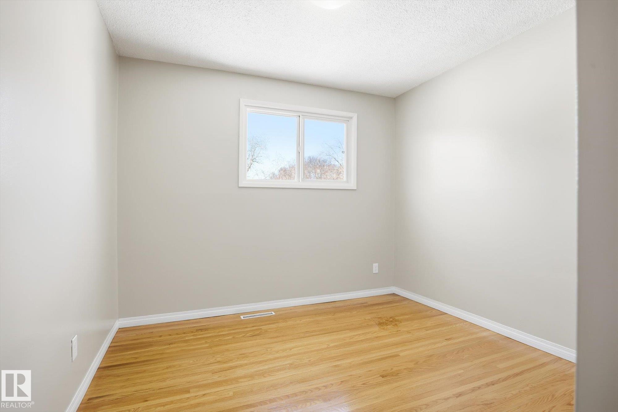 This room features light-colored walls, hardwood flooring, and a window providing natural light - 6 Garden Crescent, St. Albert, AB - Indoor Photo Showing Other Room