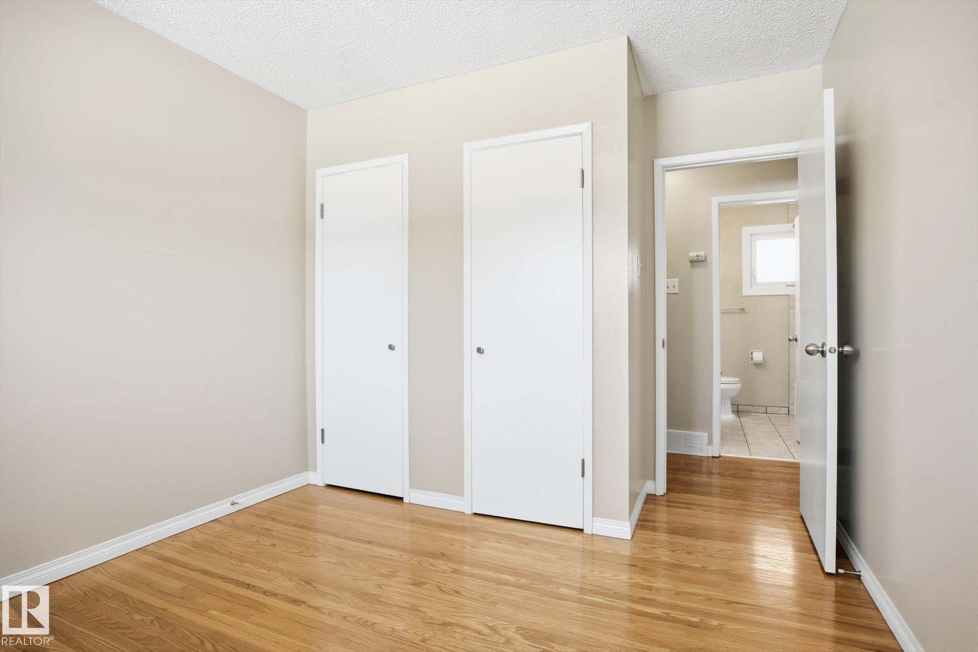 This room features hardwood floors and two white doors - 6 Garden Crescent, St. Albert, AB - Indoor Photo Showing Other Room