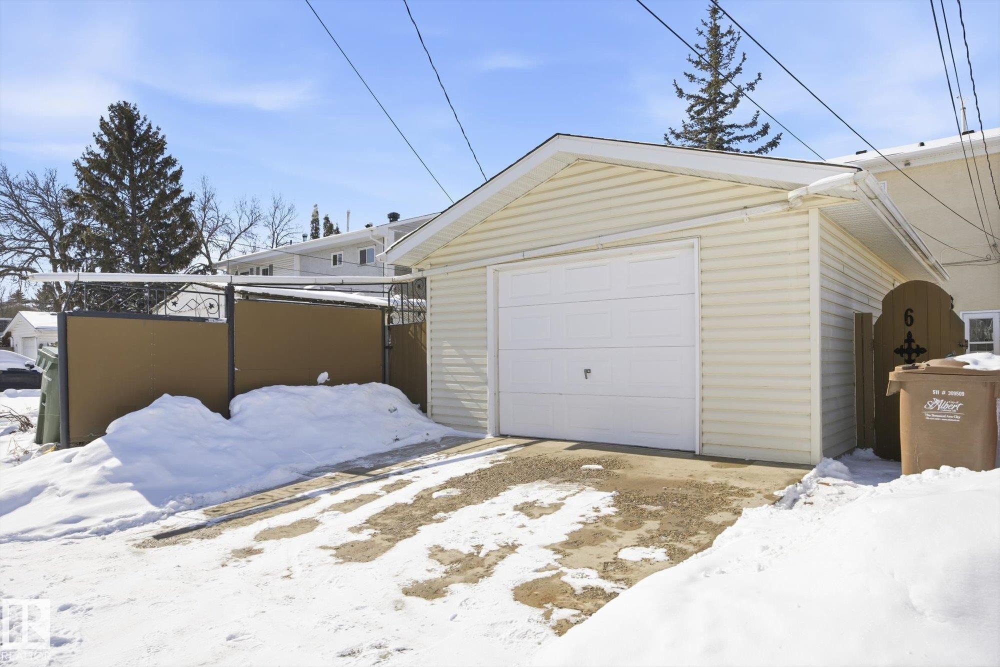The property includes a detached garage with a white garage door and light-colored siding - 6 Garden Crescent, St. Albert, AB - Outdoor With Exterior