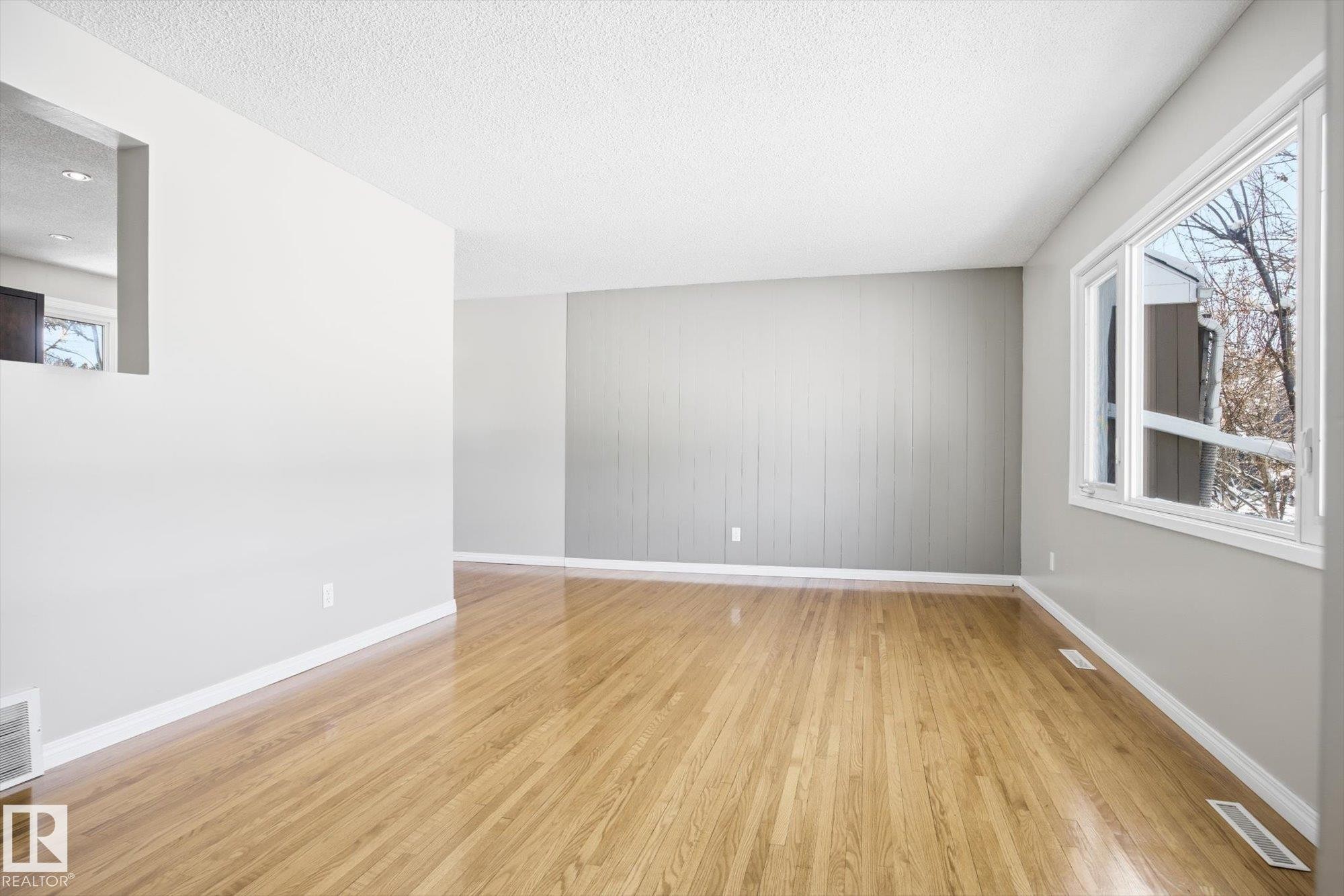 Bright living area featuring hardwood flooring and a large window - 6 Garden Crescent, St. Albert, AB - Indoor Photo Showing Other Room