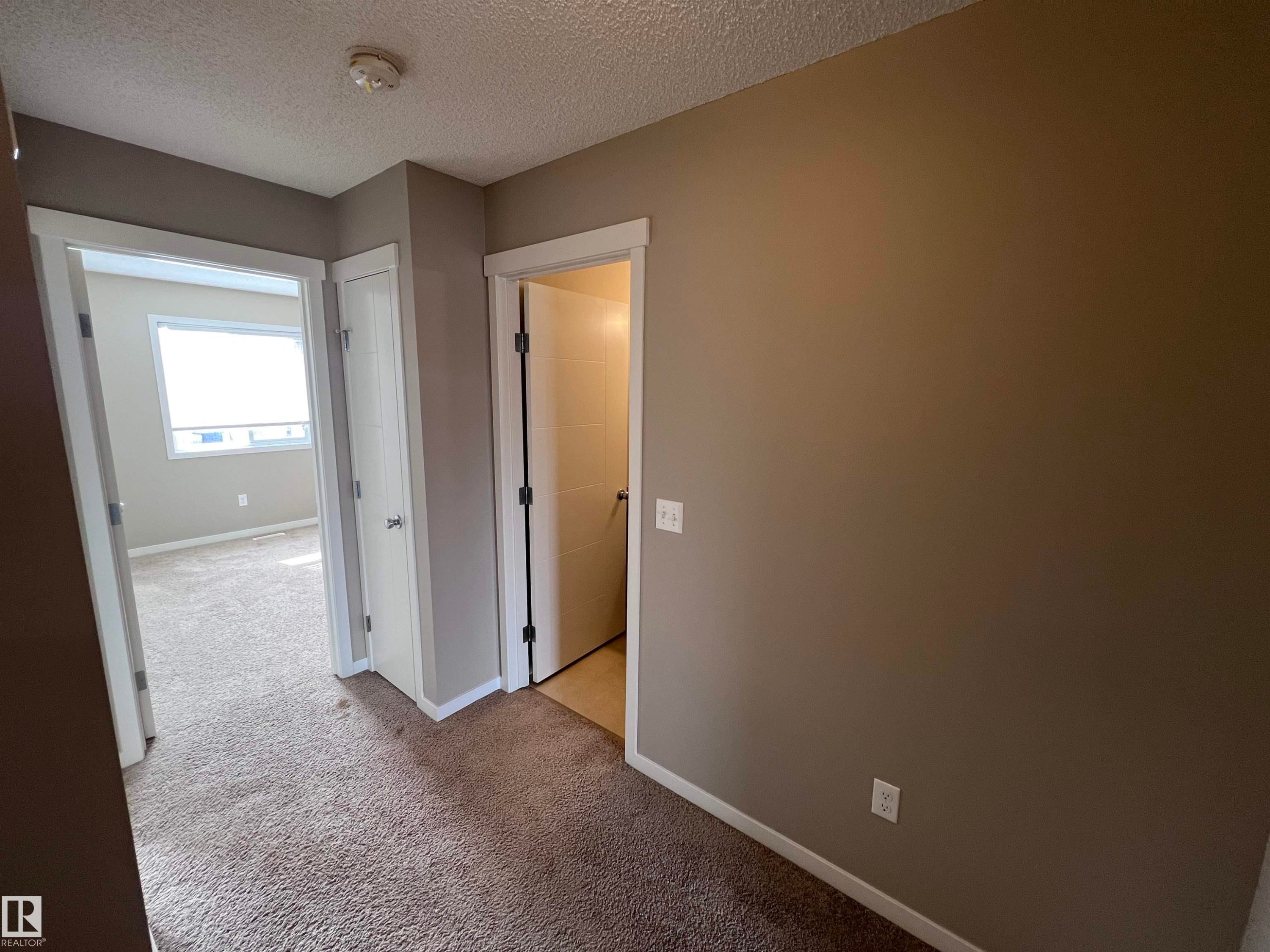 The interior features neutral wall paint and carpeting, with white trim around doorways and baseboards - 1421 26 Avenue, Edmonton, AB - Indoor Photo Showing Other Room