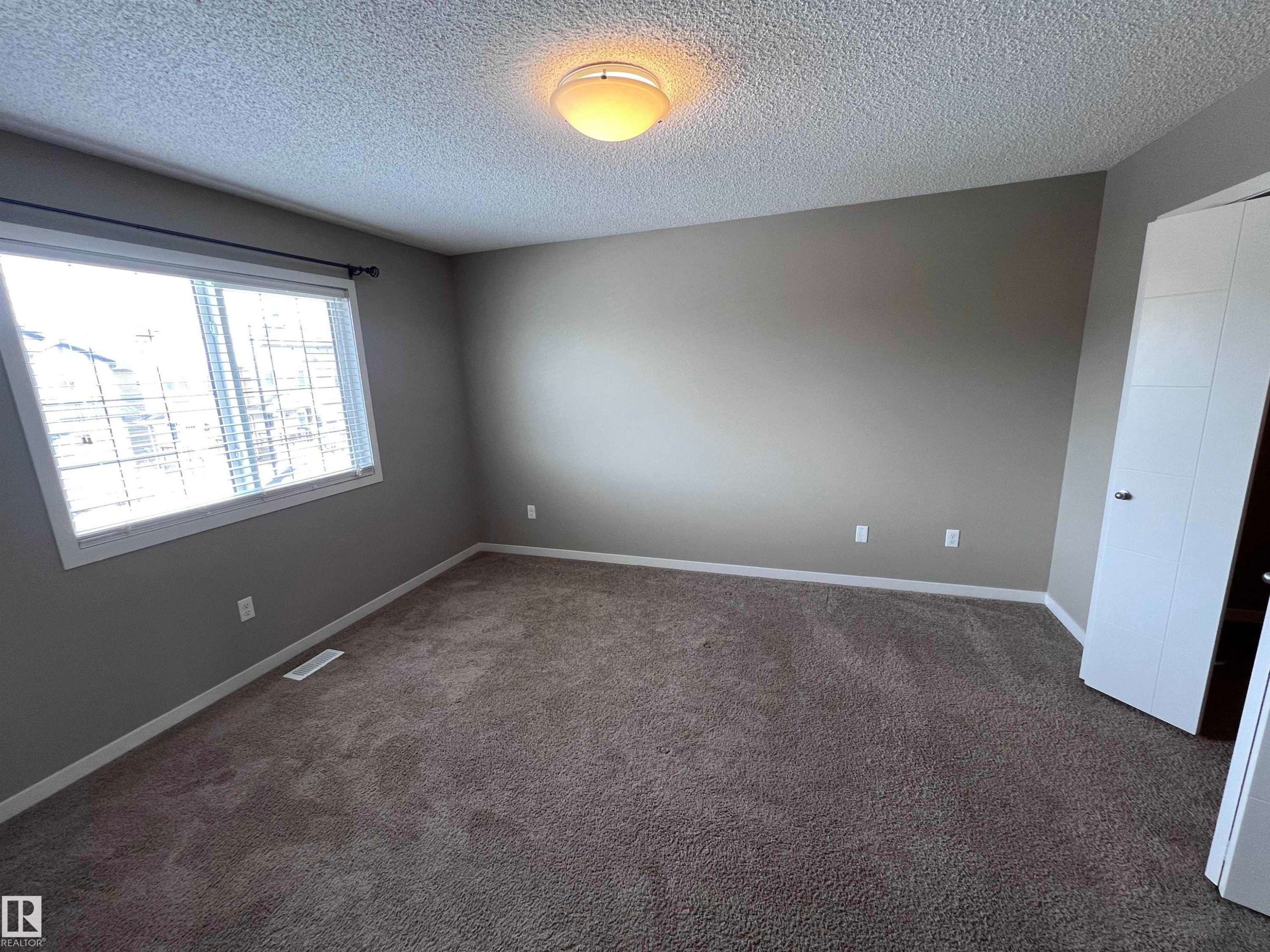 This room features neutral-toned walls, a window with blinds, and carpeting - 1421 26 Avenue, Edmonton, AB - Indoor Photo Showing Other Room