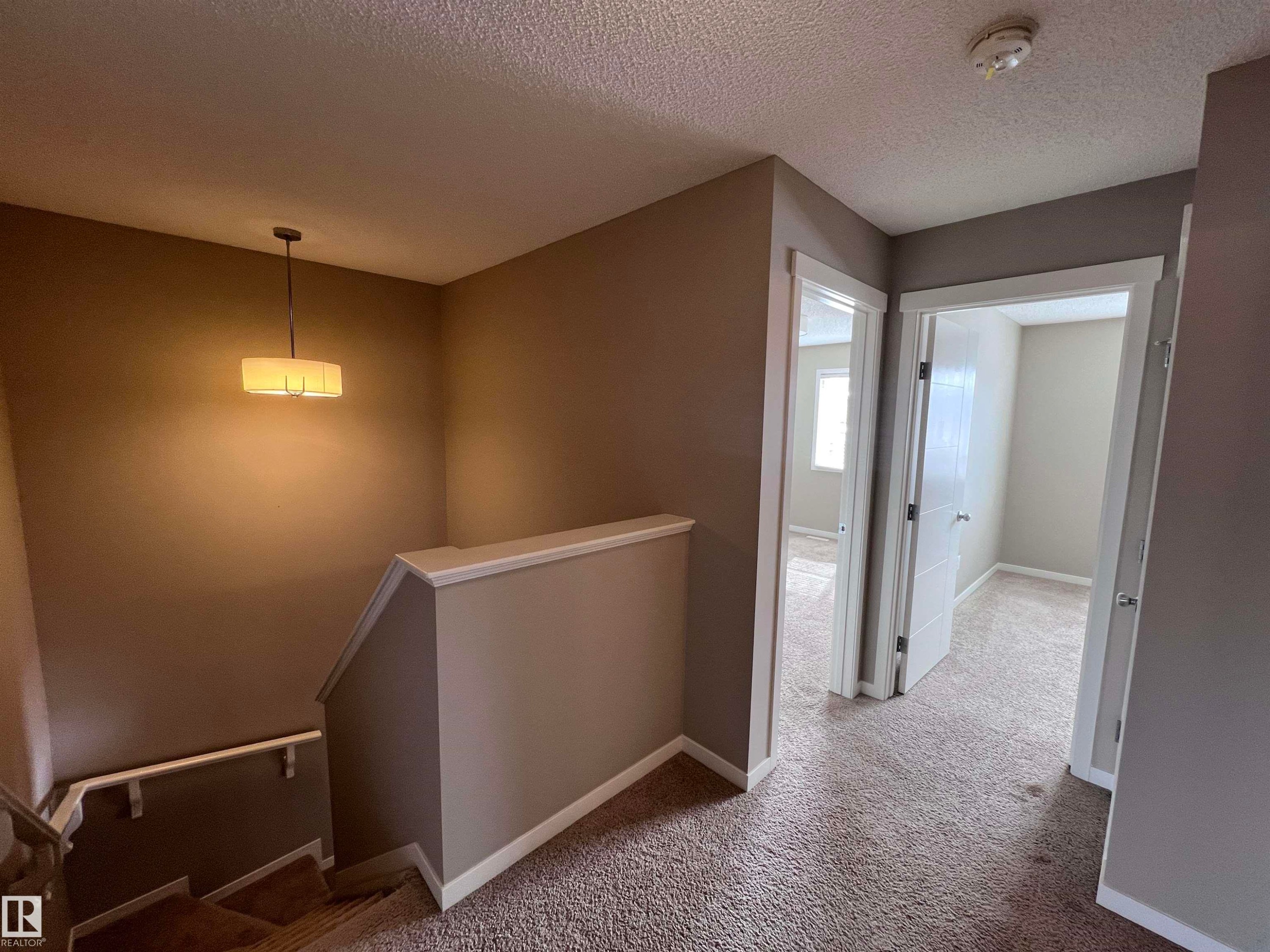 The hallway features neutral-toned walls, white trim, and carpeted flooring - 1421 26 Avenue, Edmonton, AB - Indoor Photo Showing Other Room
