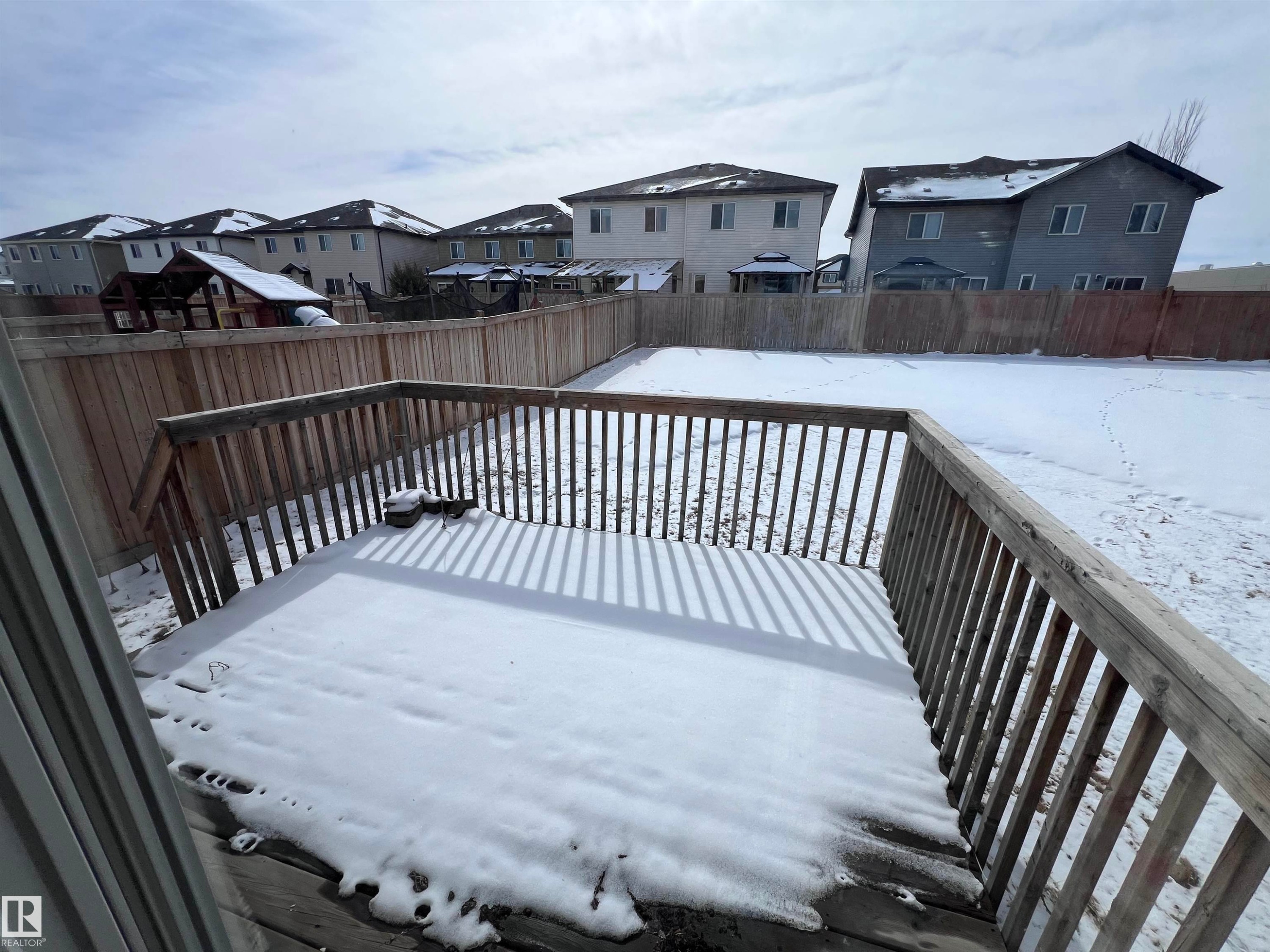 The property features a front porch with wood planking and railings, supported by a column with stone detailing - 1421 26 Avenue, Edmonton, AB - Outdoor