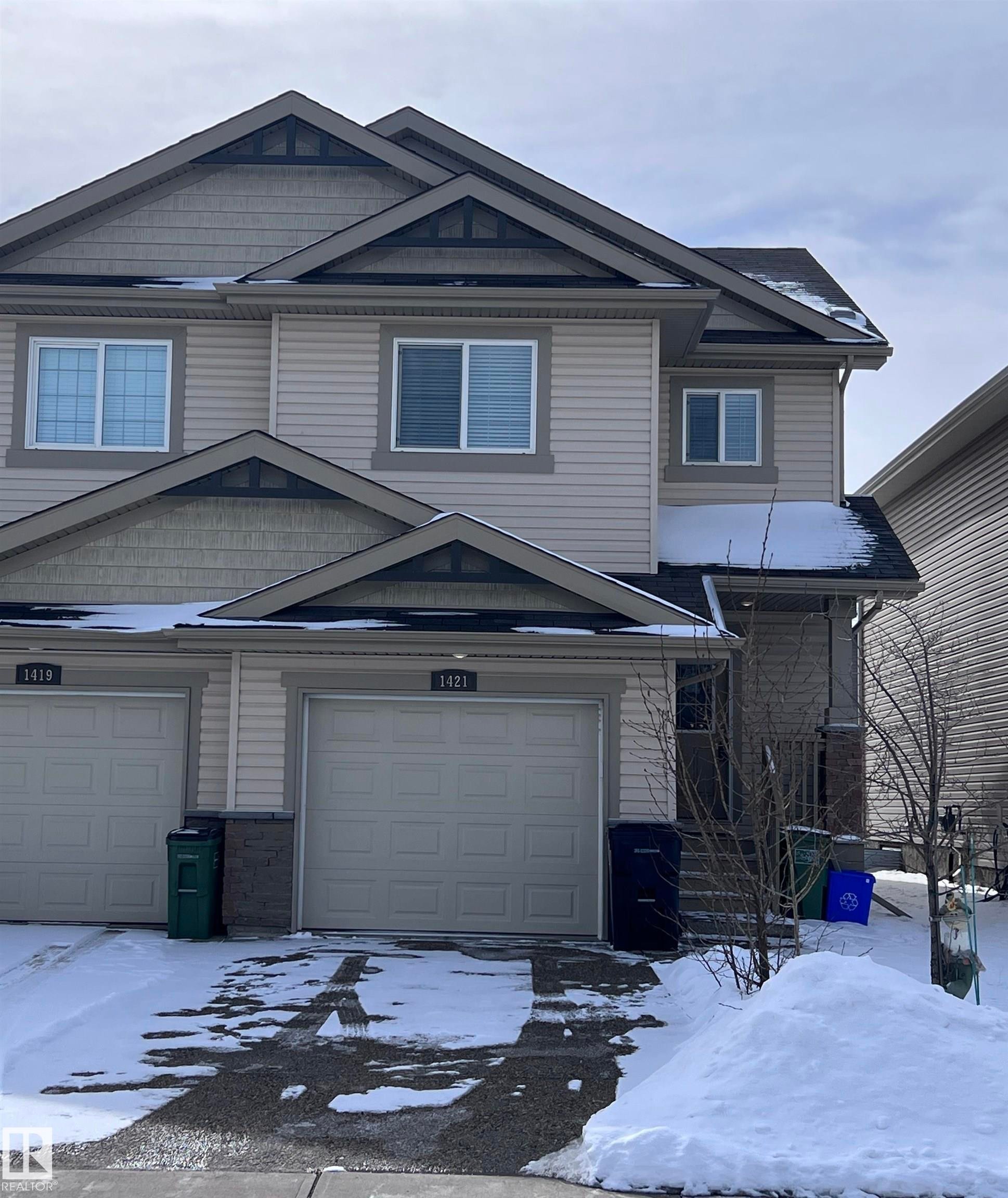 This property features a two-story design with light-colored siding and a multi-level roofline - 1421 26 Avenue, Edmonton, AB - Outdoor