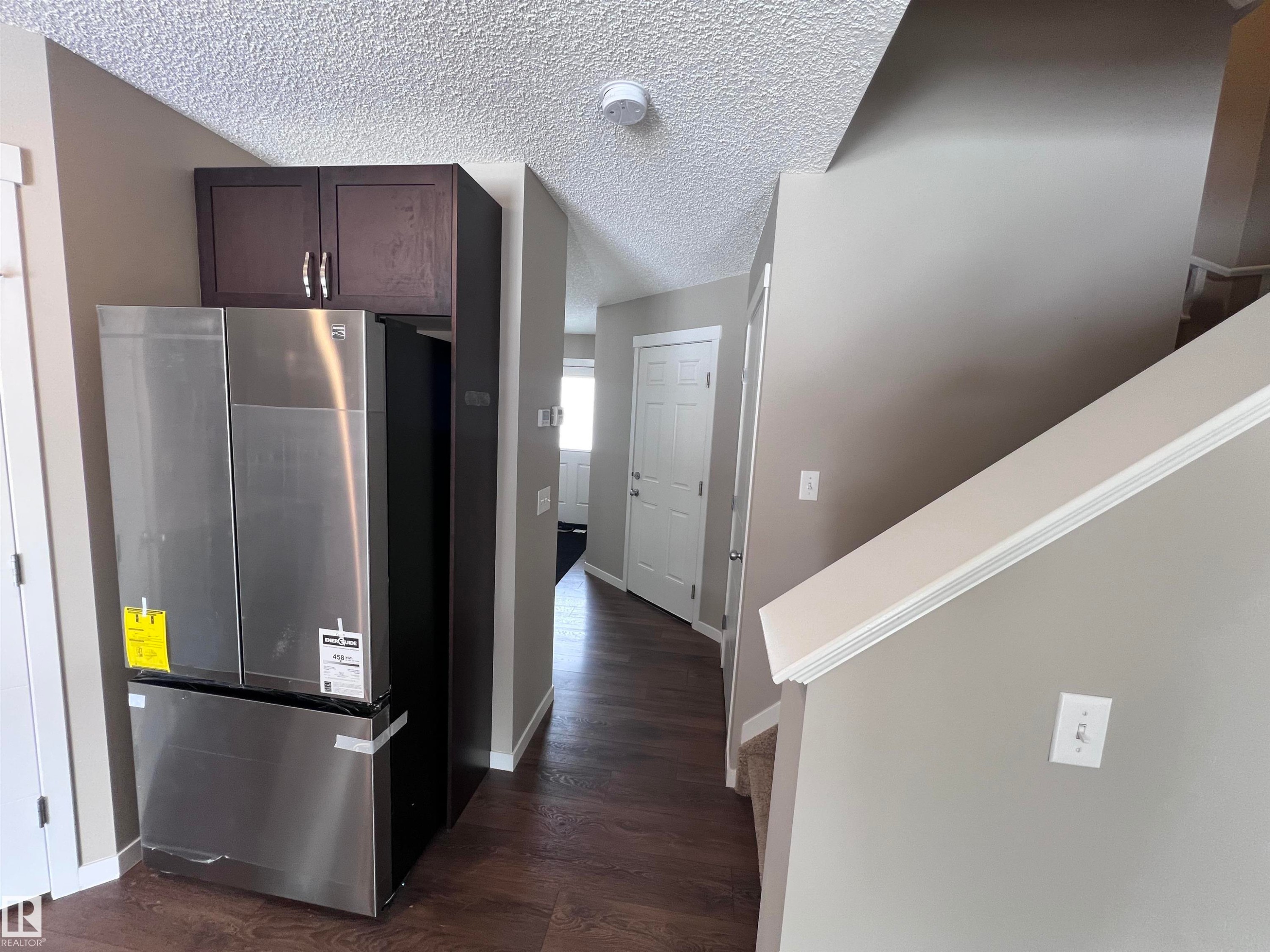 The property features dark wood flooring, a white interior door, and a staircase with a carpeted runner - 1421 26 Avenue, Edmonton, AB - Indoor Photo Showing Other Room