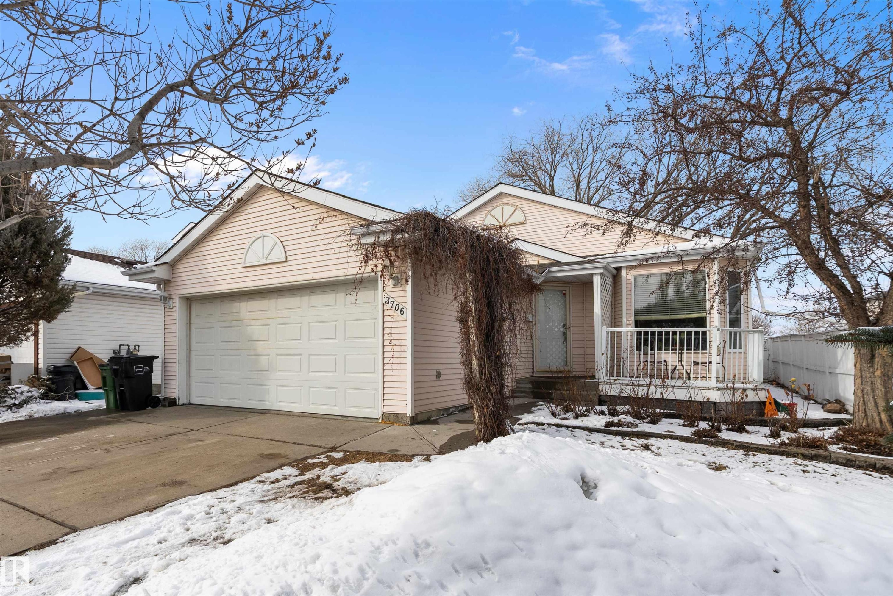 The property features a one-car garage with a white door, a front porch with white railings, and light-colored siding - 3706 131A Avenue, Edmonton, AB - Outdoor With Deck Patio Veranda