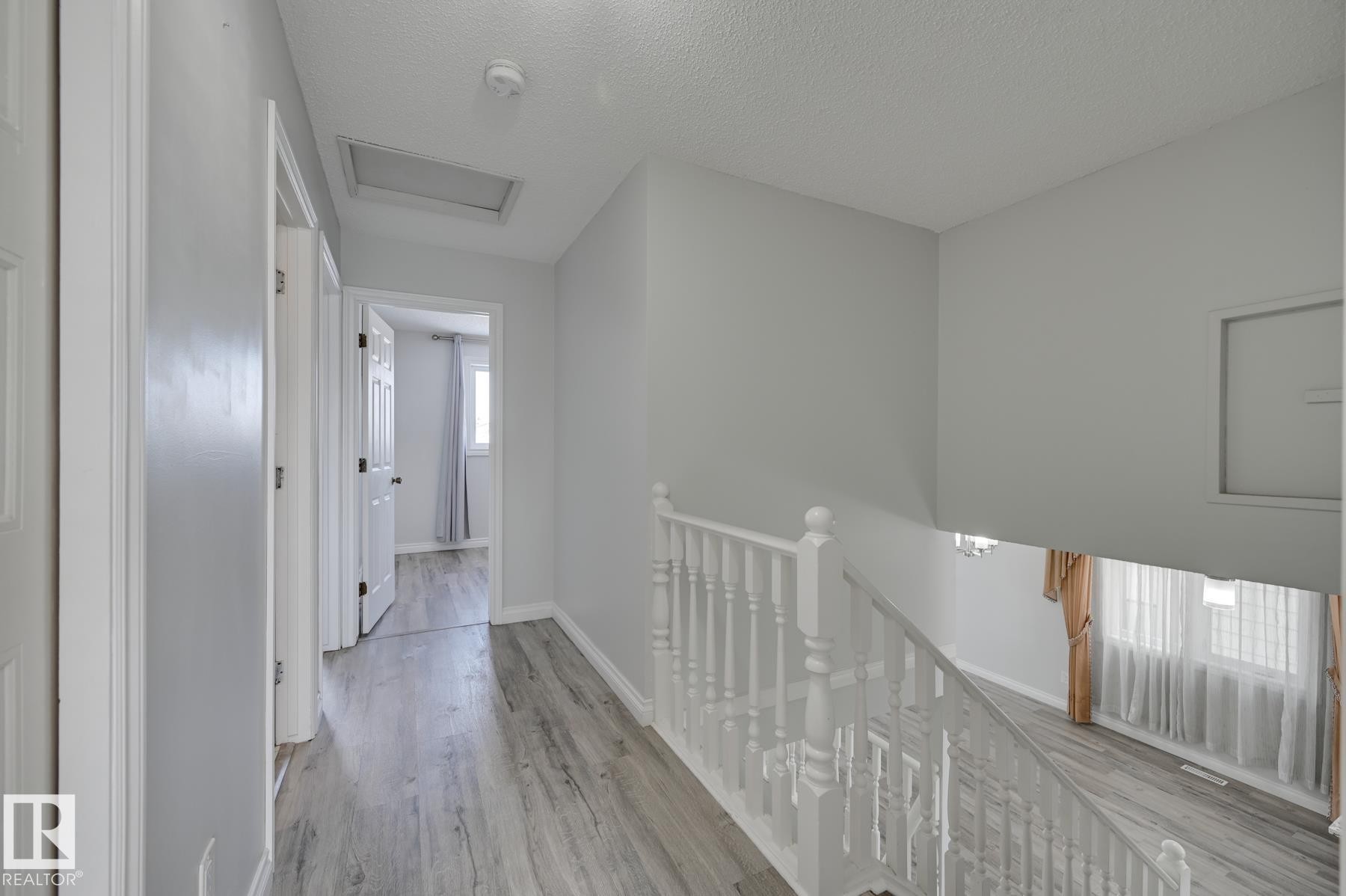 The property features light gray walls and wood-style flooring throughout - 8507 152B Avenue, Edmonton, AB - Indoor Photo Showing Other Room