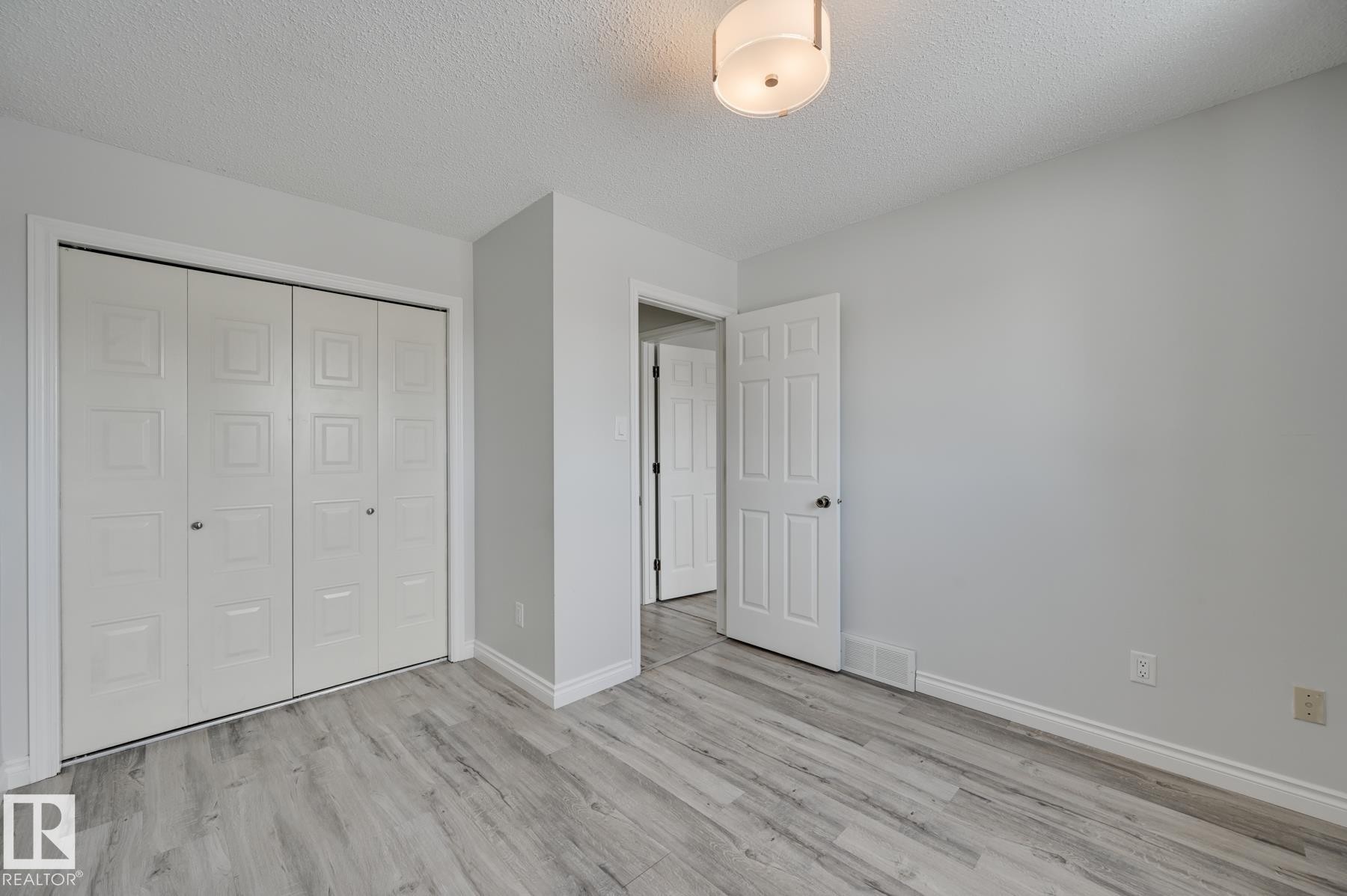 This room features light-toned flooring, white walls, and a ceiling light fixture - 8507 152B Avenue, Edmonton, AB - Indoor Photo Showing Other Room