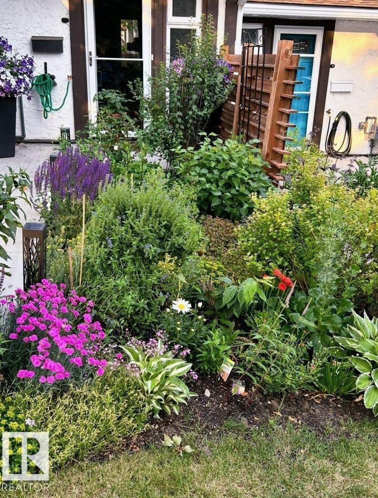 The property features a garden with a variety of mature plants and vibrant flowers - 91 Hearthstone, Edmonton, AB - Outdoor