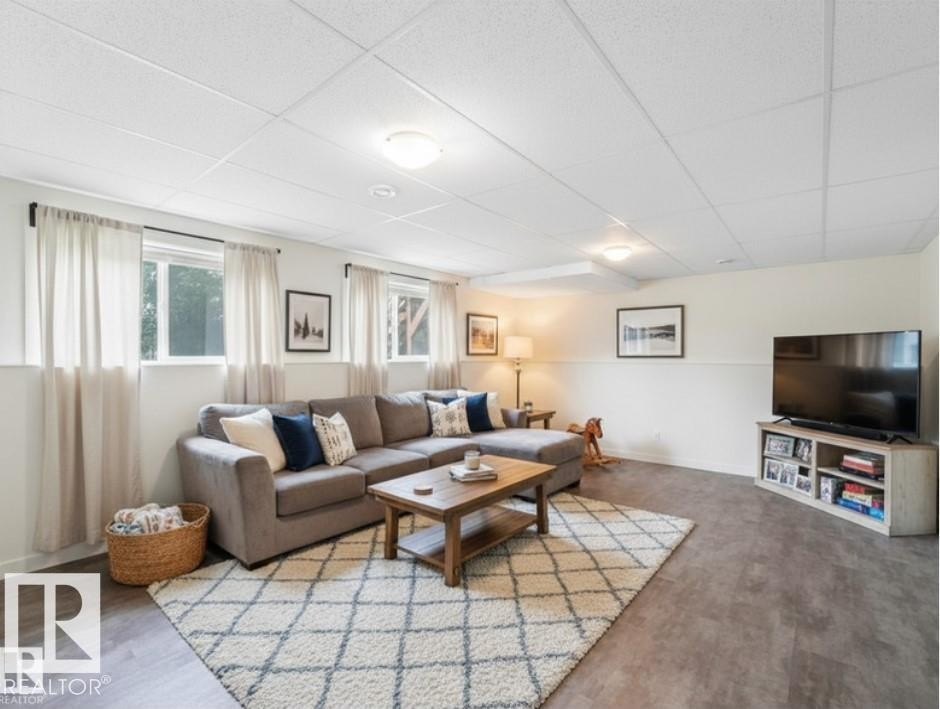 This bright living area features windows that provide natural light, light-colored walls, and durable flooring, creating a comfortable space - 5035 51 Avenue, Lamont, AB - Indoor Photo Showing Living Room