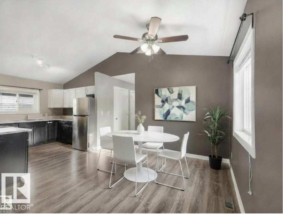 The kitchen and dining area feature durable flooring, a vaulted ceiling, and a ceiling fan with light fixture - 5035 51 Avenue, Lamont, AB - Indoor Photo Showing Other Room