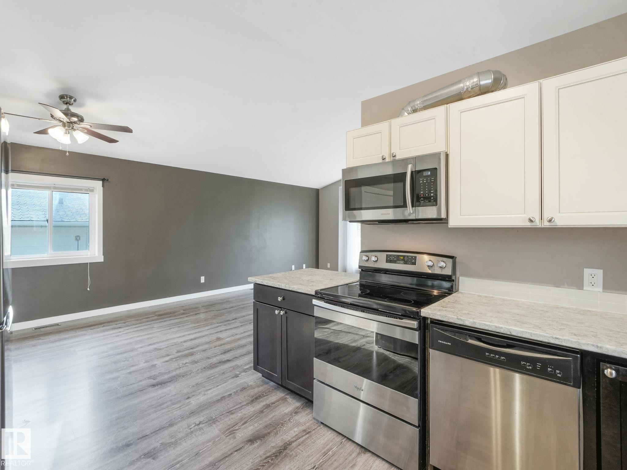 The kitchen features stainless steel appliances, including a microwave, oven, and dishwasher - 5035 51 Avenue, Lamont, AB - Indoor Photo Showing Kitchen