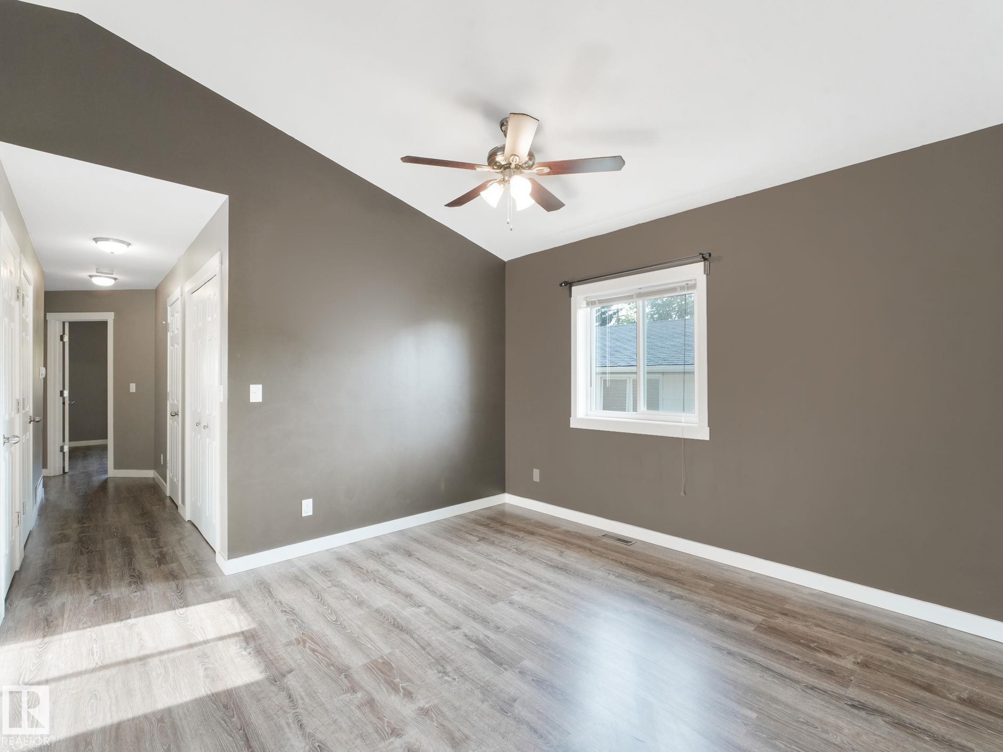 Spacious room with sloped ceilings, a ceiling fan, and light wood-style flooring - 5035 51 Avenue, Lamont, AB - Indoor Photo Showing Other Room