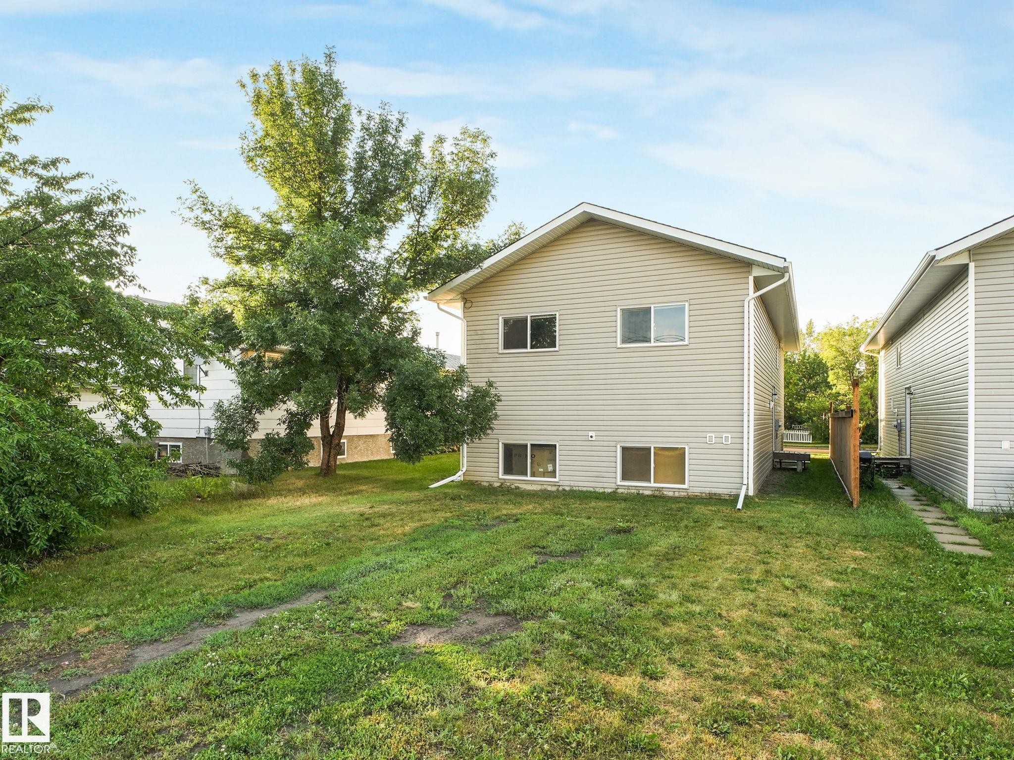 Exterior featuring light beige horizontal siding and white trim - 5035 51 Avenue, Lamont, AB - Outdoor