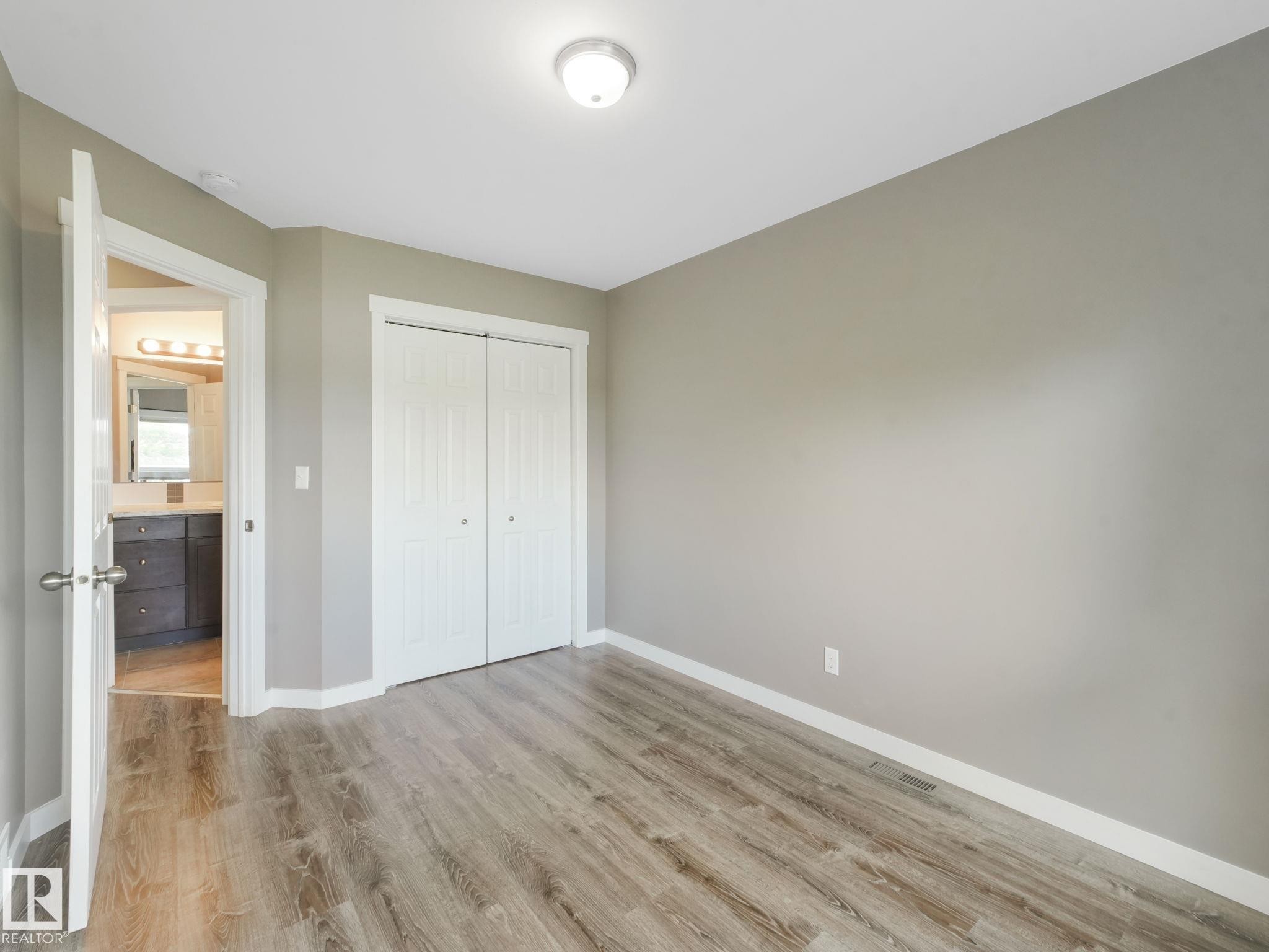 This room features light wood-look flooring, light gray walls, and a ceiling-mounted light fixture - 5035 51 Avenue, Lamont, AB - Indoor Photo Showing Other Room