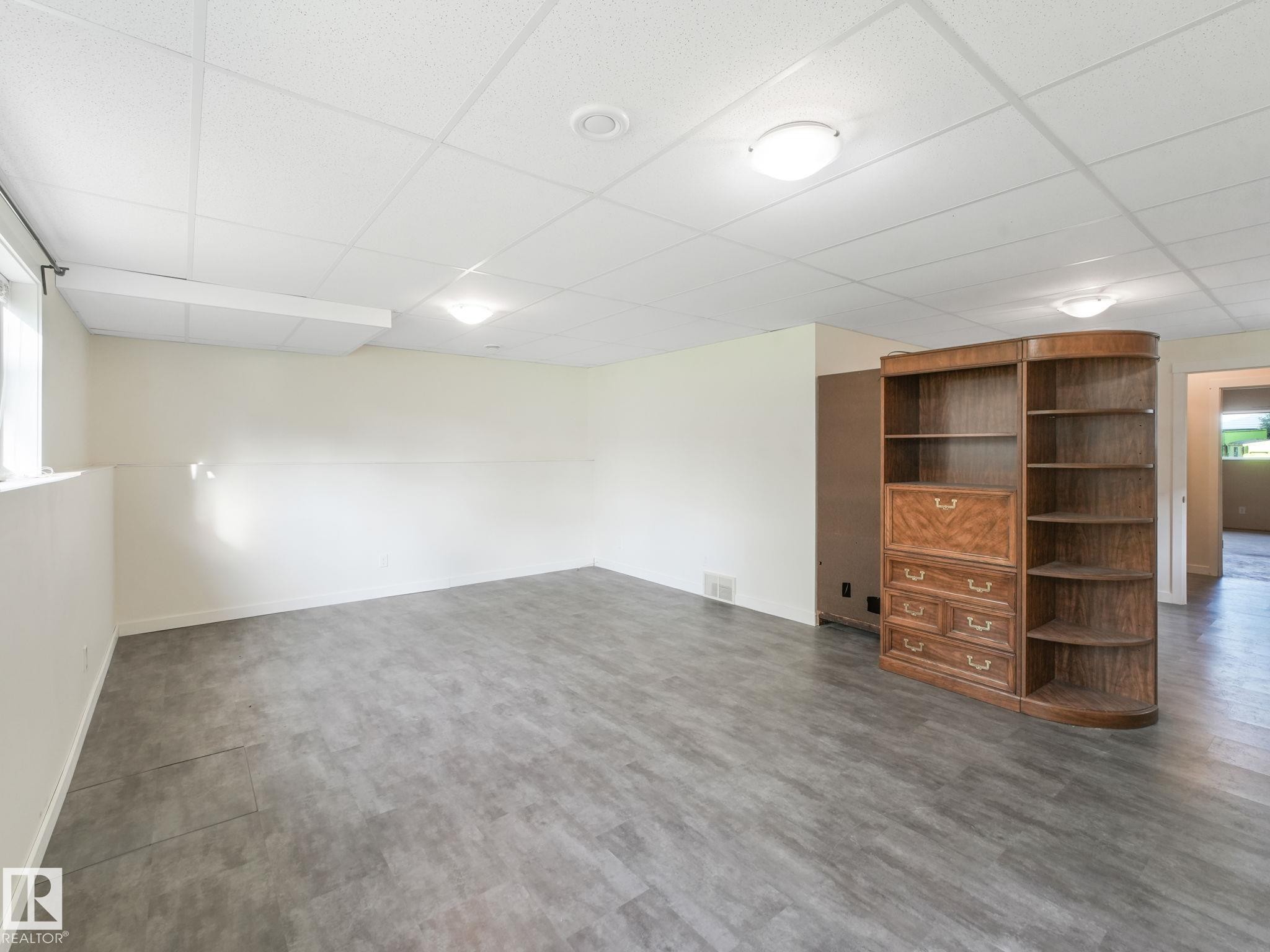 Spacious room featuring light-colored walls, recessed ceiling lights, and durable grey flooring - 5035 51 Avenue, Lamont, AB - Indoor Photo Showing Other Room