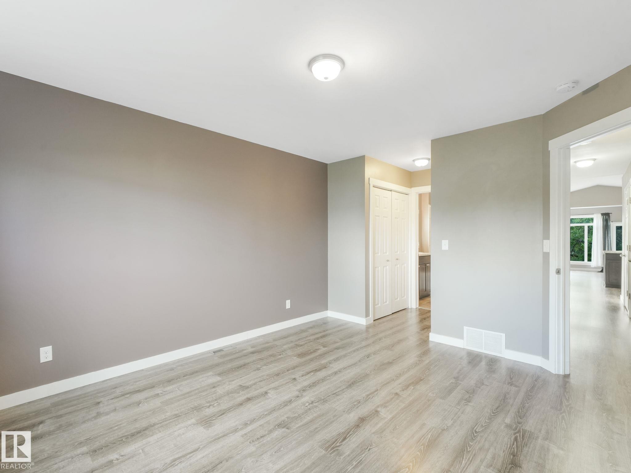 This inviting room features light-toned wood-style flooring, neutral wall paint, and overhead lighting - 5035 51 Avenue, Lamont, AB - Indoor Photo Showing Other Room