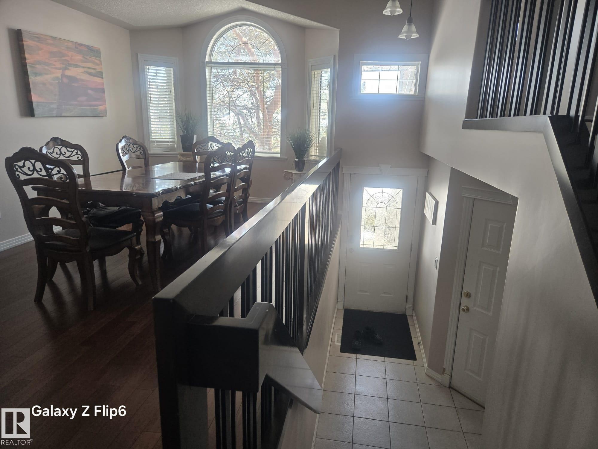 This property features an inviting entryway with tile flooring and a front door with a decorative glass insert - Edmonton, AB - Indoor Photo Showing Dining Room