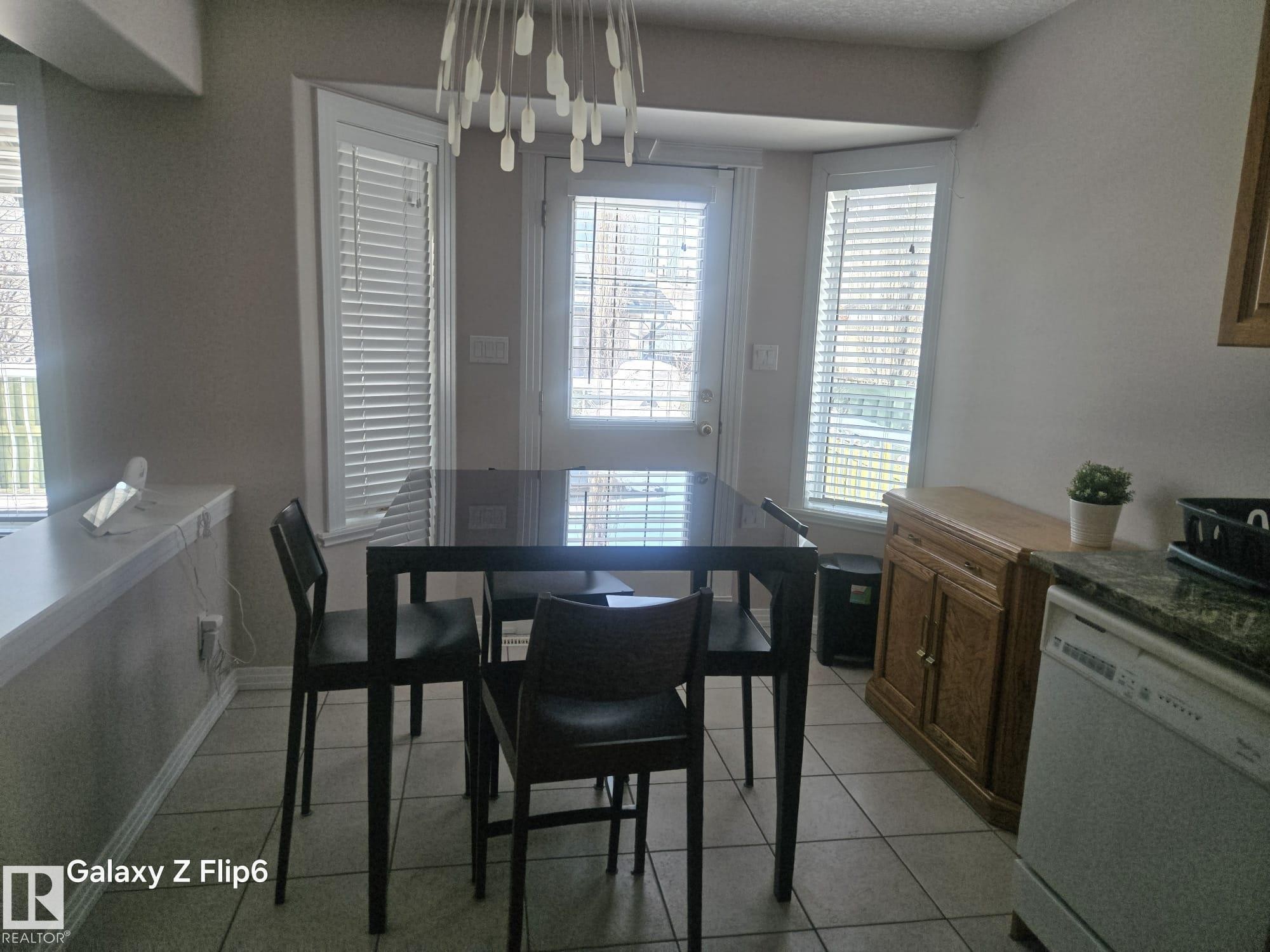 The dining area features bay windows with blinds and a tile floor - Edmonton, AB - Indoor Photo Showing Dining Room