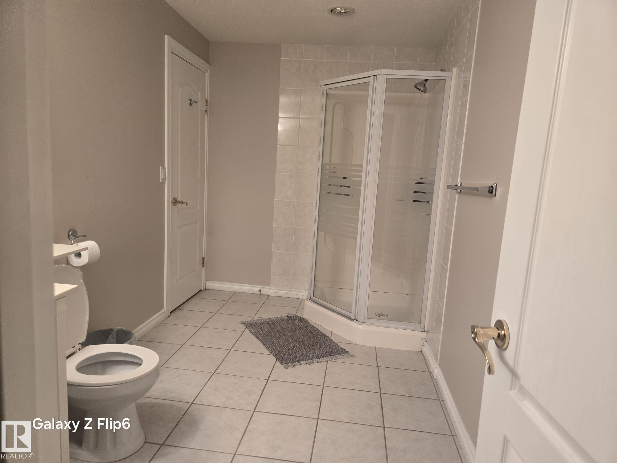 This bathroom features light-colored tile flooring and walls painted in a neutral tone - Edmonton, AB - Indoor Photo Showing Bathroom