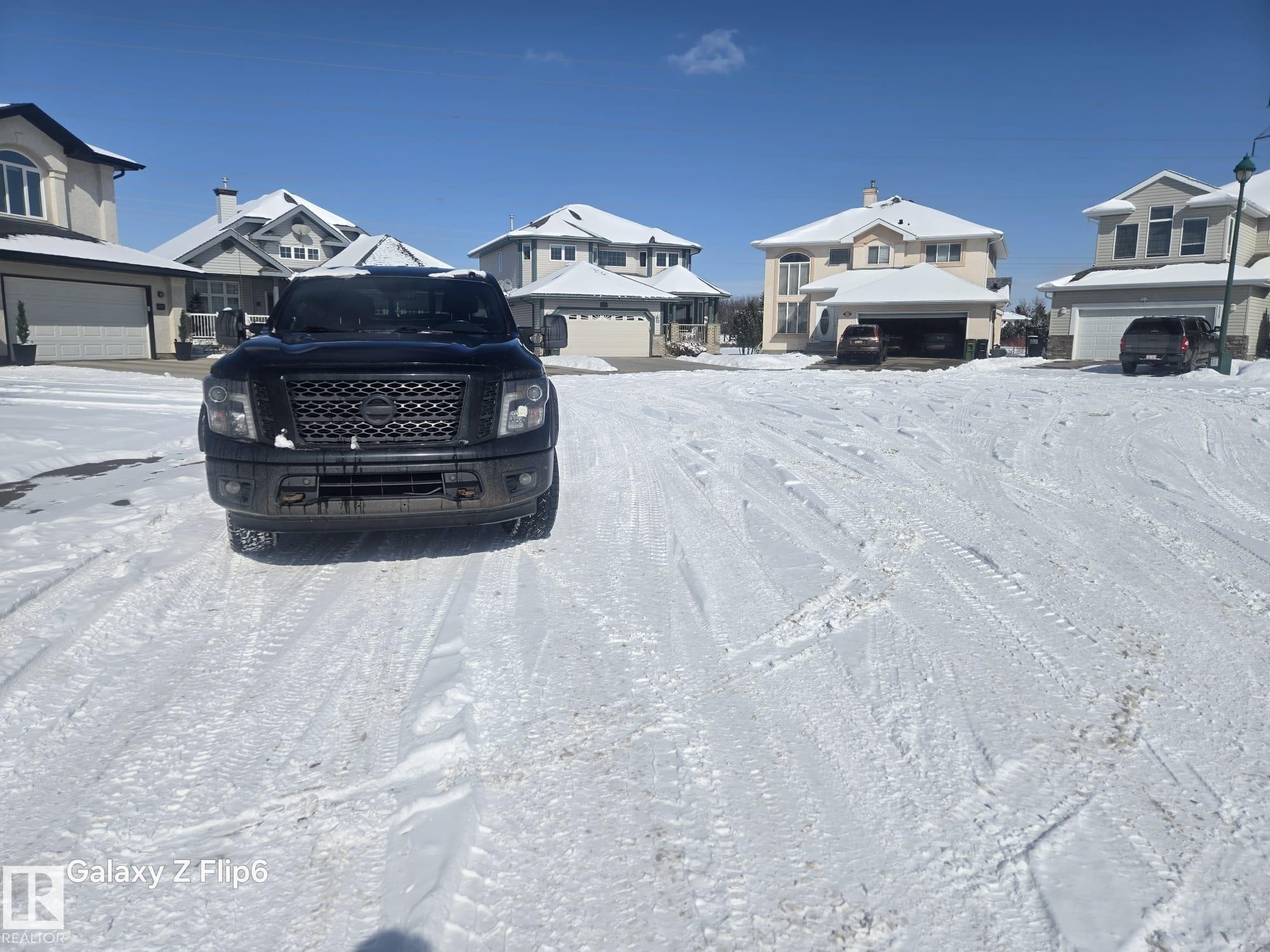 The property is part of a residential neighborhood featuring several detached houses with attached garages and snow-covered roofs - Edmonton, AB - Outdoor With Facade