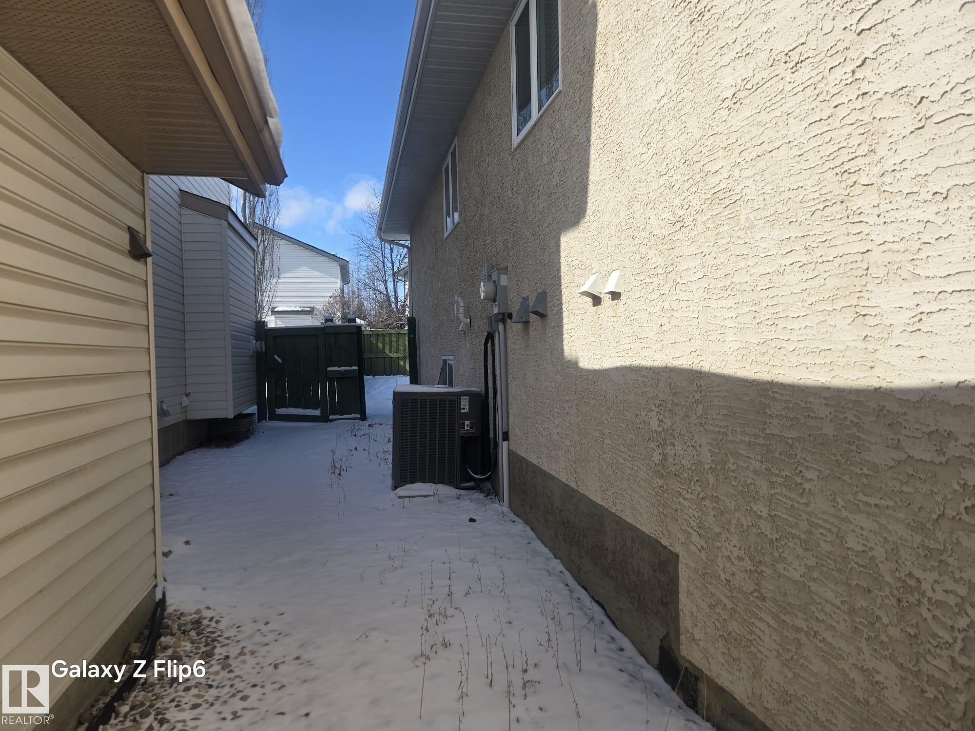 The exterior of the property features textured stucco siding and white framed windows - Edmonton, AB - Outdoor With Exterior