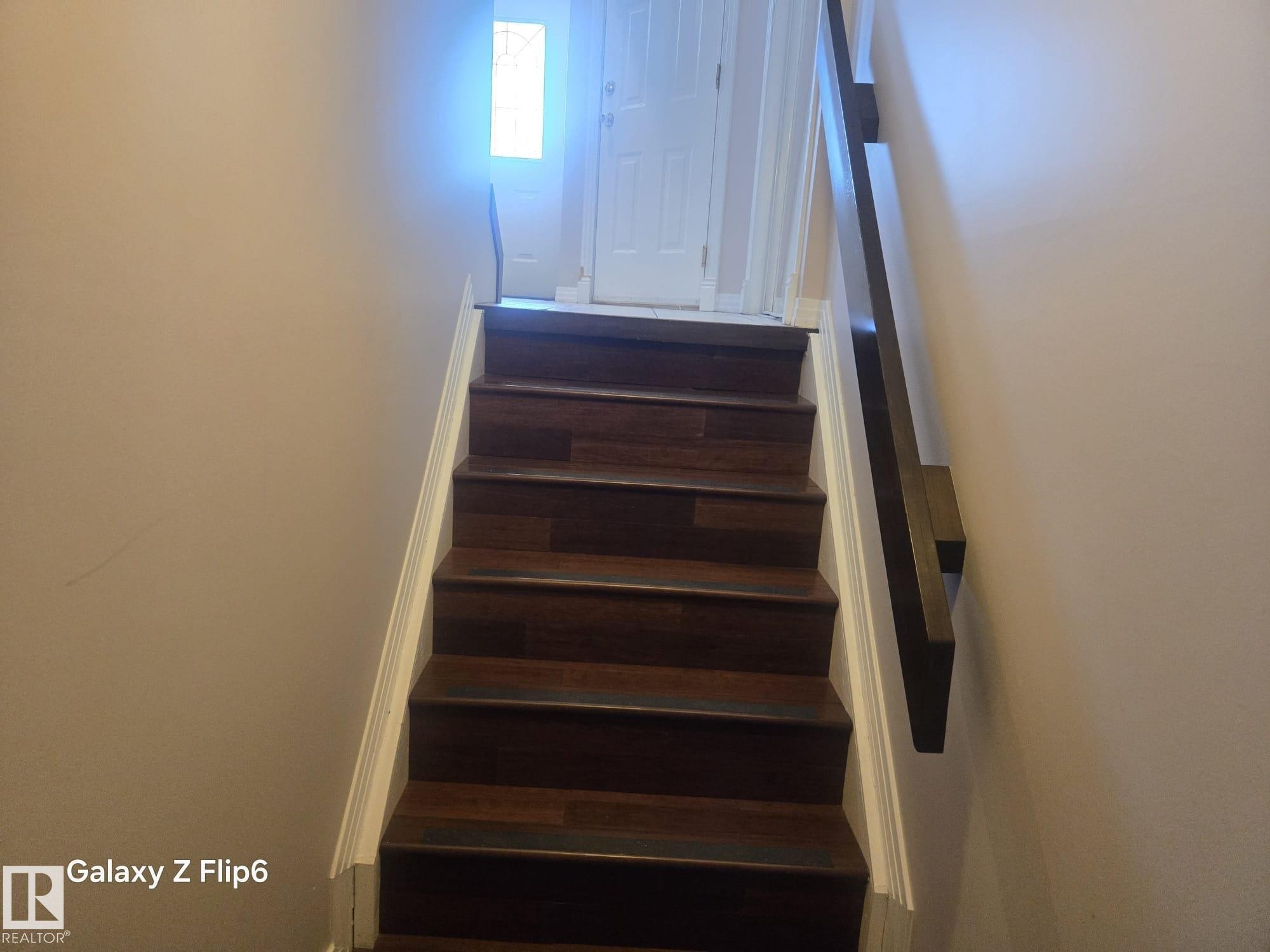 The property features dark wood flooring on the staircase, complemented by white risers and trim - Edmonton, AB - Indoor Photo Showing Other Room