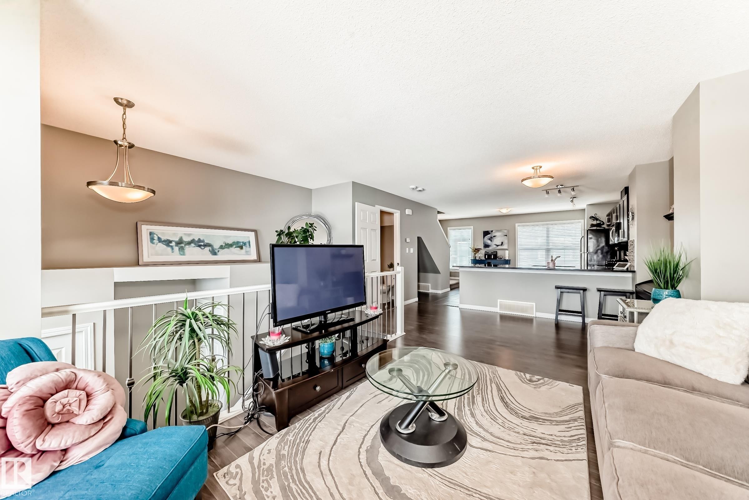 This property features an open-concept living area with dark hardwood flooring and light-colored walls - 86 4029 Orchards Drive, Edmonton, AB - Indoor Photo Showing Living Room