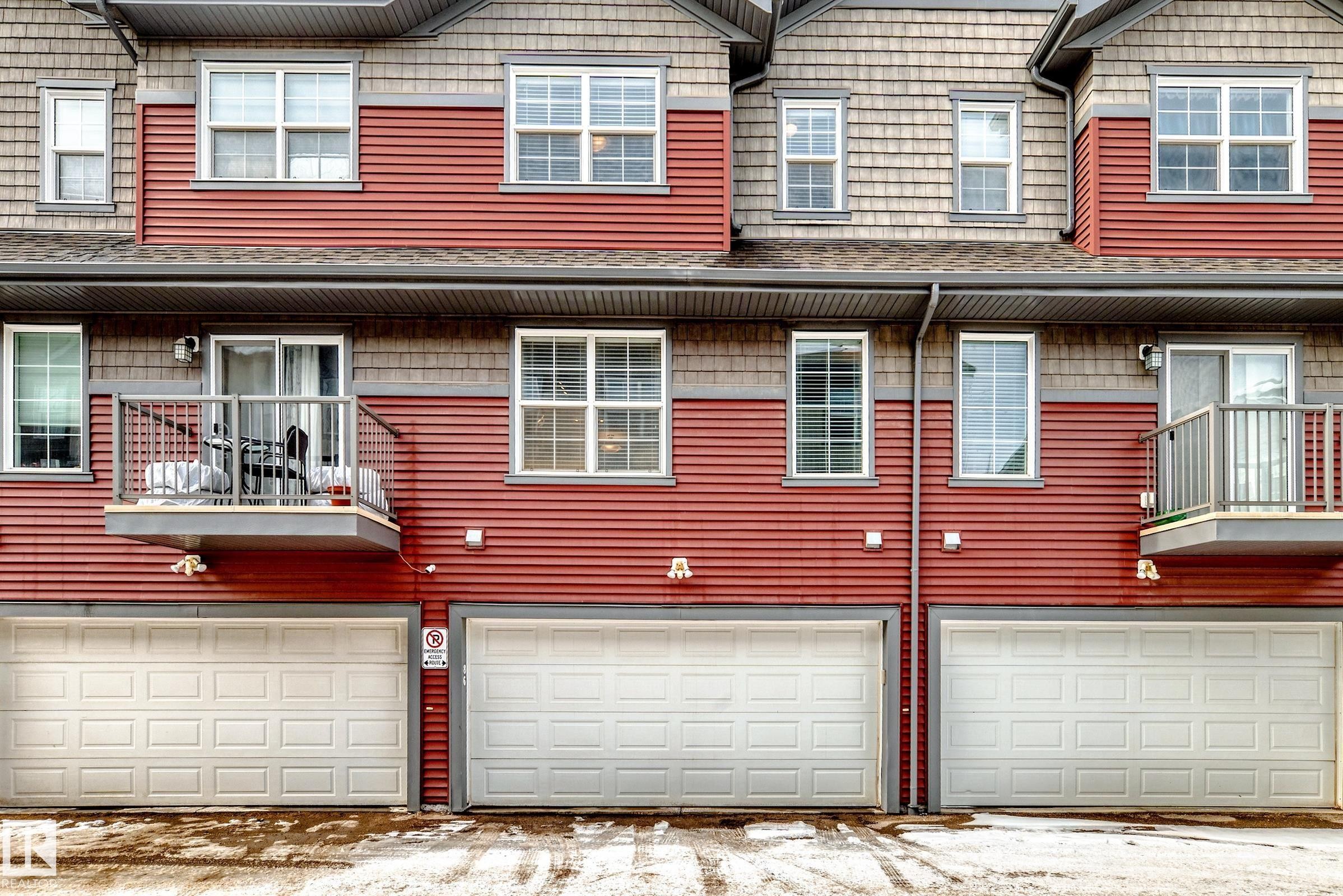 The property features red siding and light-colored shingles - 86 4029 Orchards Drive, Edmonton, AB - Outdoor With Facade With Exterior