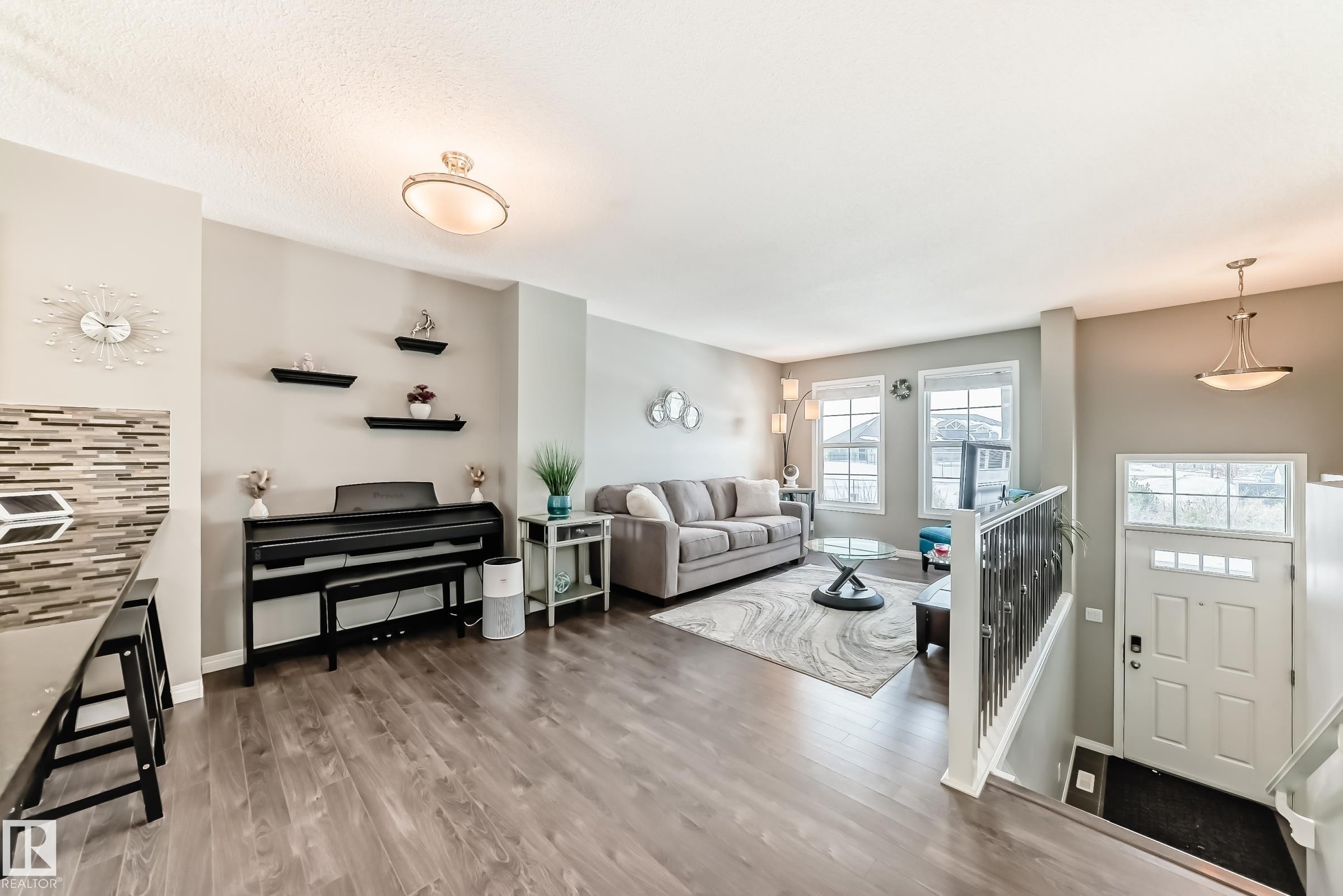 The main living area features wood-look flooring and light-colored walls, creating an open and inviting atmosphere - 86 4029 Orchards Drive, Edmonton, AB - Indoor Photo Showing Other Room