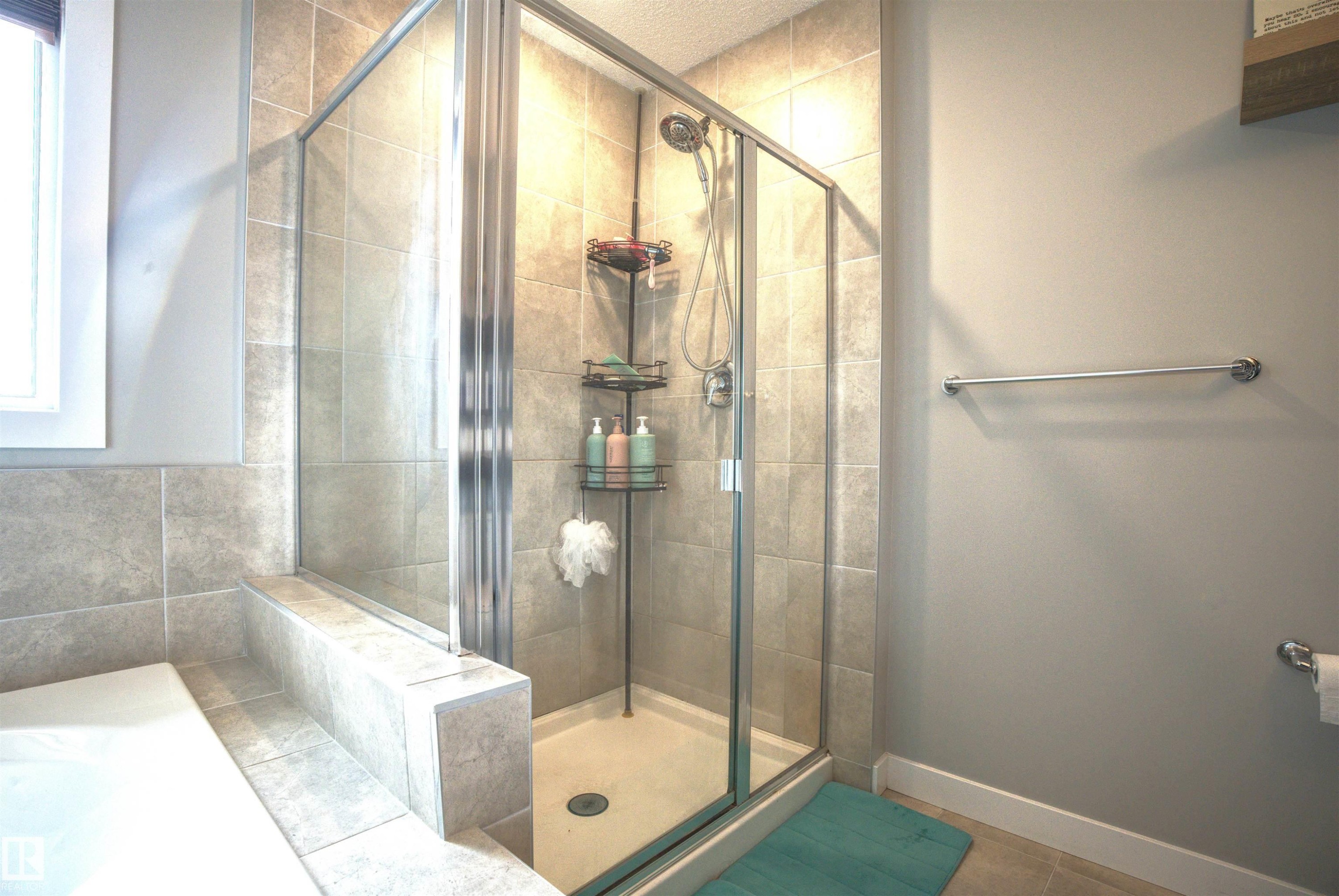 Bathroom with a glass-enclosed shower featuring tiled walls and a built-in shelf - 20503 99 Avenue, Edmonton, AB - Indoor Photo Showing Bathroom