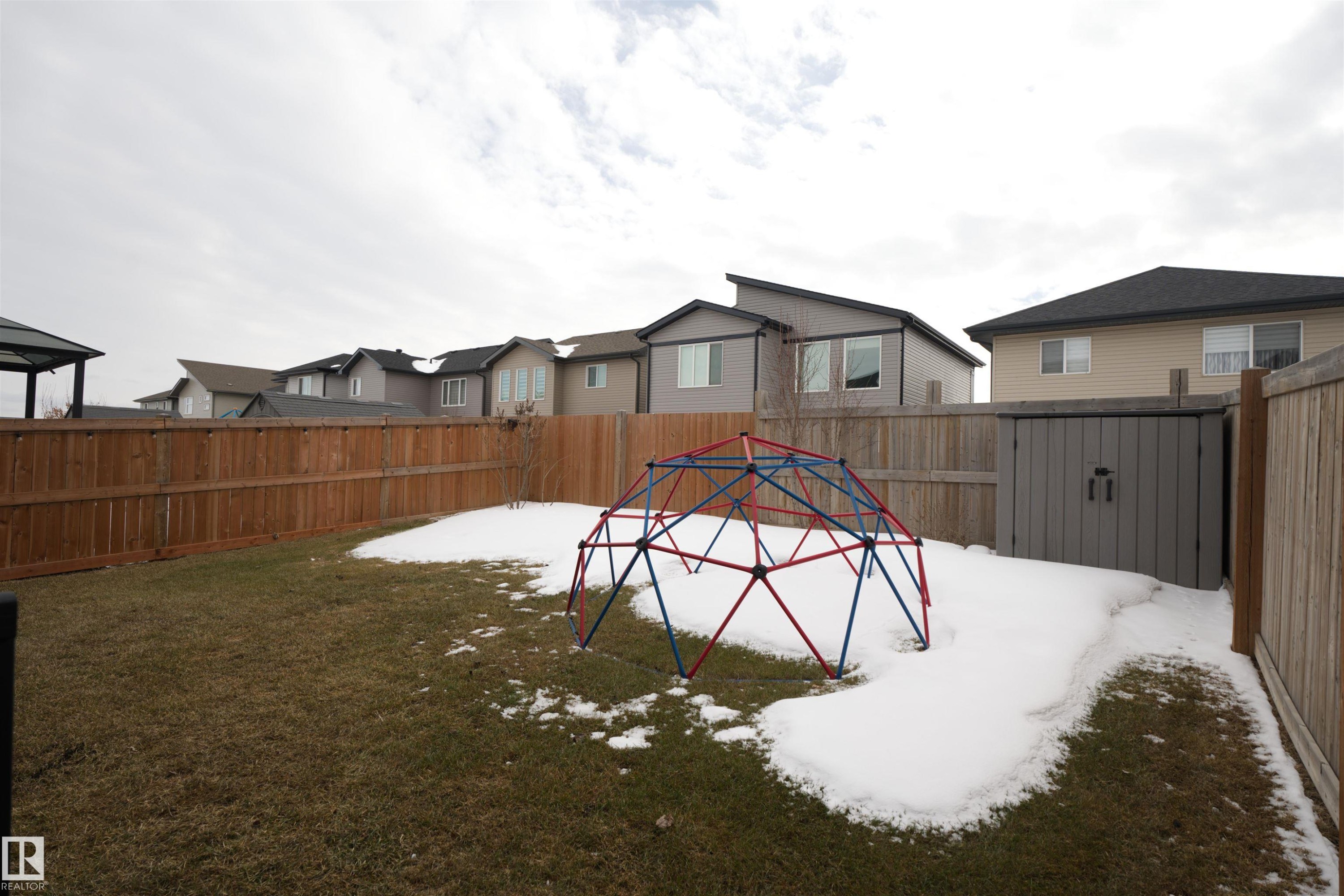 The property features a fenced yard with a lawn and a storage shed - 20503 99 Avenue, Edmonton, AB - Outdoor
