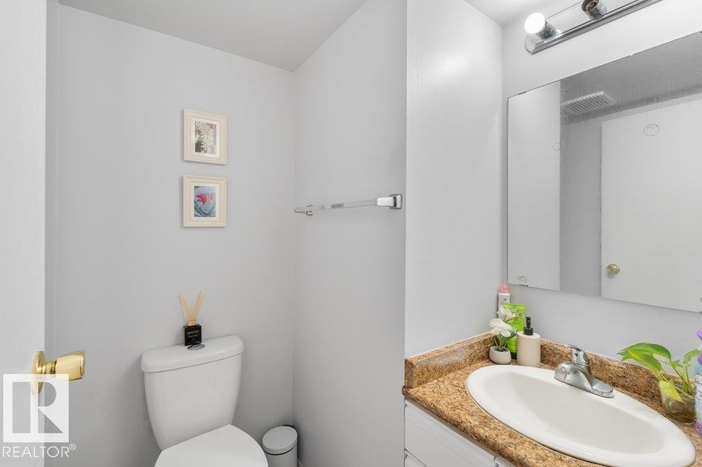 Bathroom featuring a vanity with a granite-style countertop, an integrated sink, and a mirror with overhead lighting - 638 Saddleback Road, Edmonton, AB - Indoor Photo Showing Bathroom